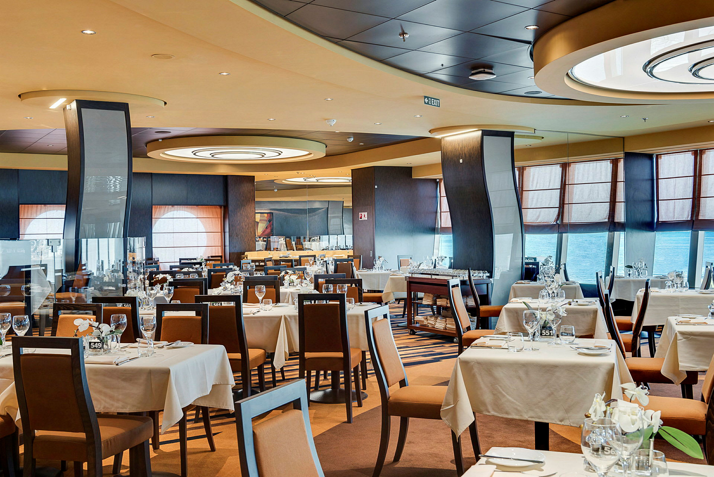 Interiør af en rummelig restaurant med dækkede borde og stole. (AI-genereret tekst)