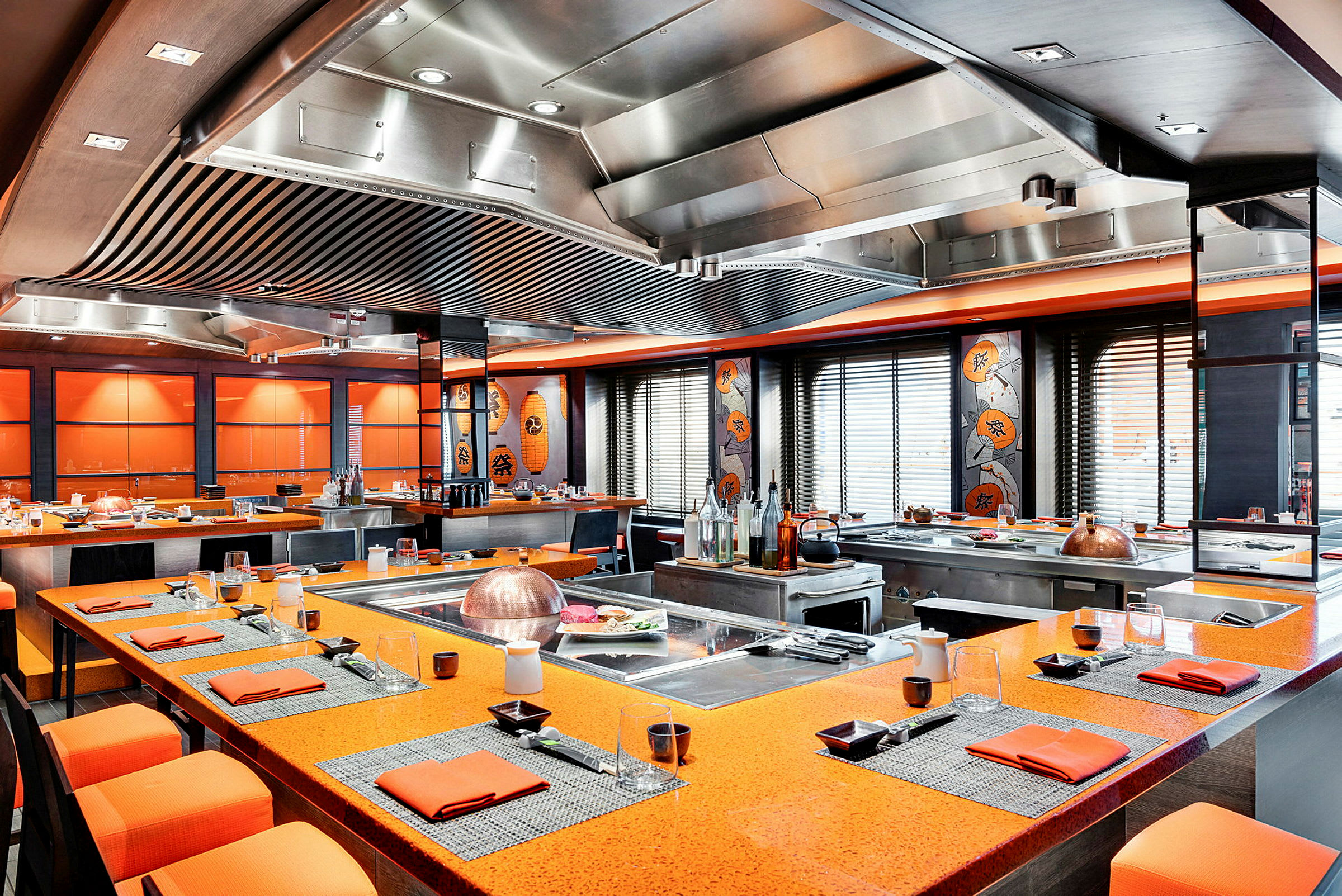 Et restaurantområde med orange bordoverflader, dekoreret med asiatisk kunst og stil. (AI-genereret tekst)