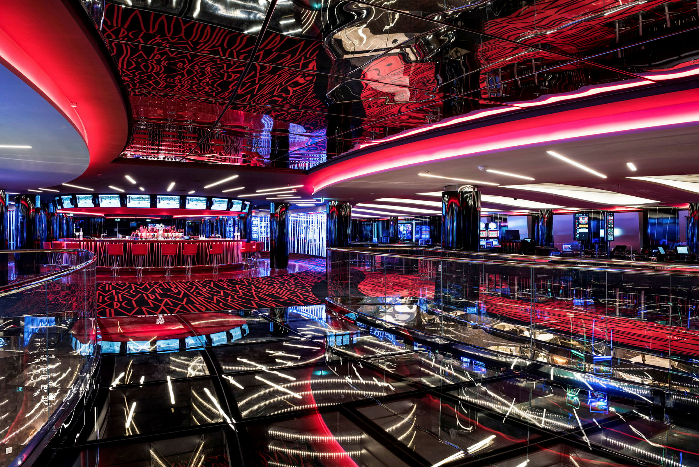 Et casinokompleks med moderne interiør i rødt og sort, reflekterende overflader og lysdekorationer. (AI-genereret tekst)
