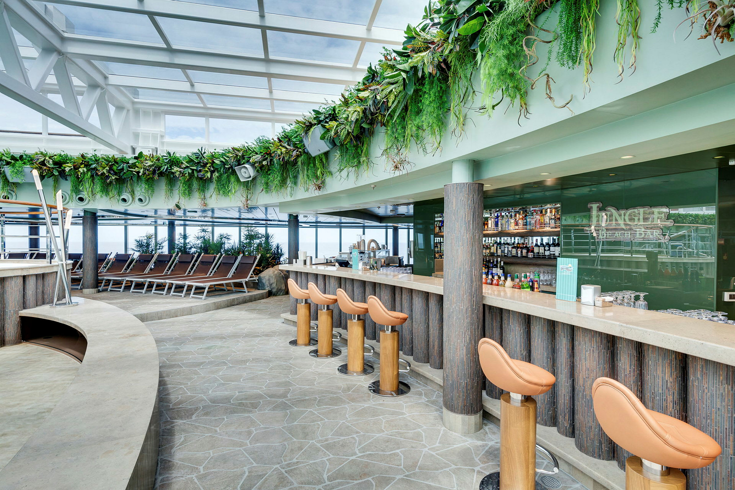 En moderne bar med stole og en grøn dekoration på væggene, samt liggestole ved siden af. (AI-genereret tekst)