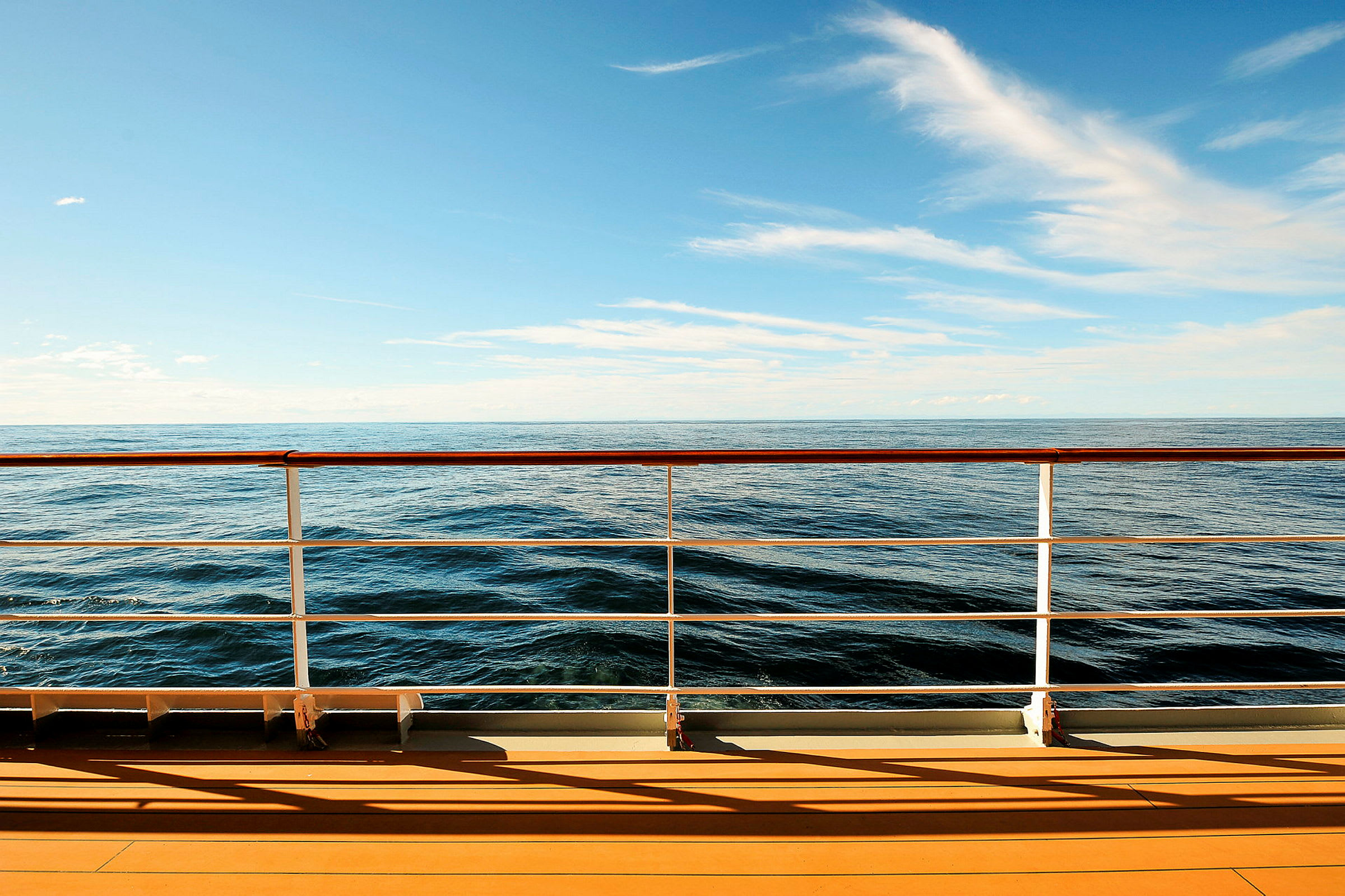 Udsigt over havet fra et skibsdæk med rækværk. (AI-genereret tekst)