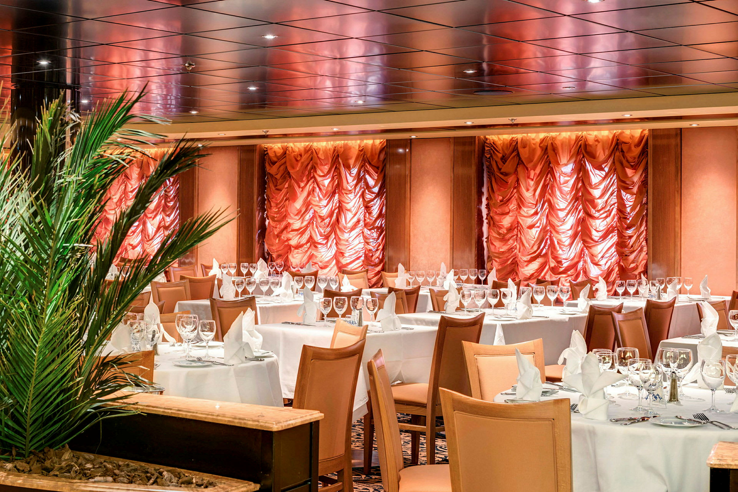 En elegant restaurant med opdækkede borde og tekstilpynt på væggene. (AI-genereret tekst)
