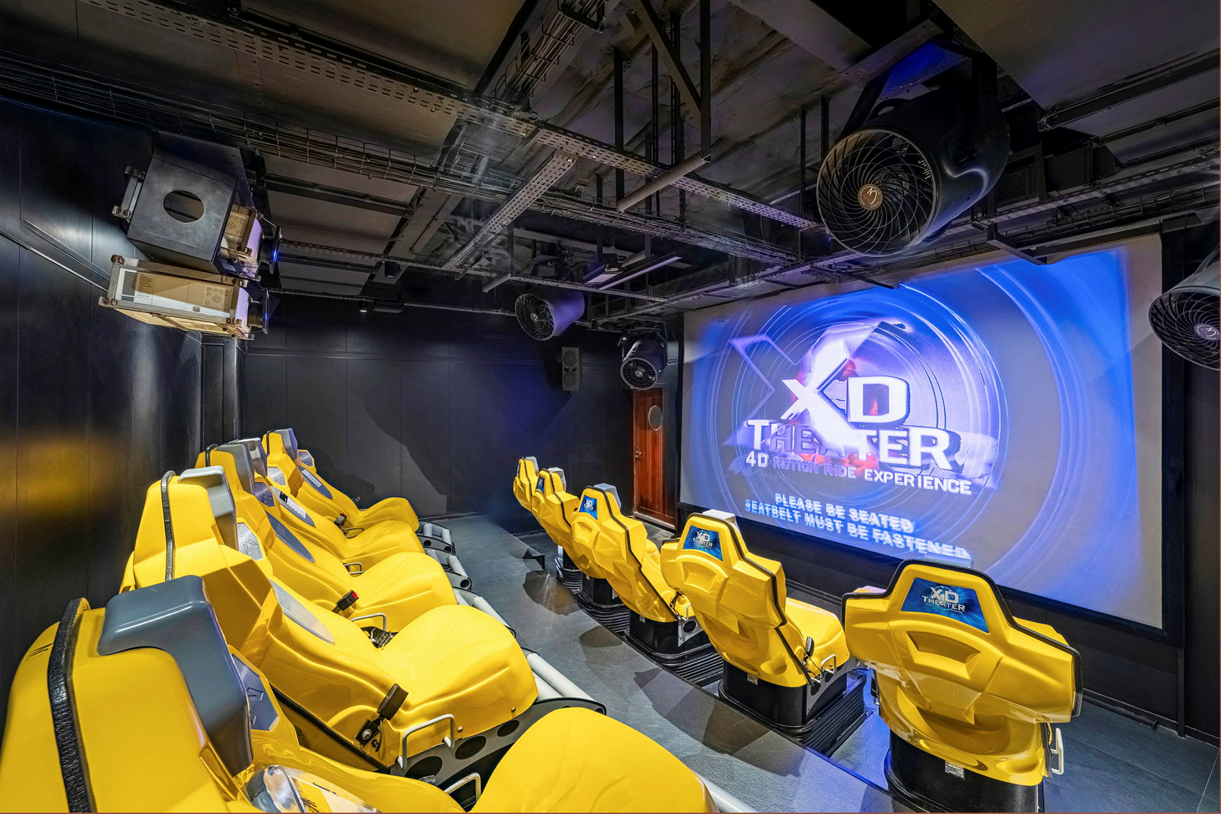 Interiør af en 4D-biograf med gule stole og en stor skærm. (AI-genereret tekst)