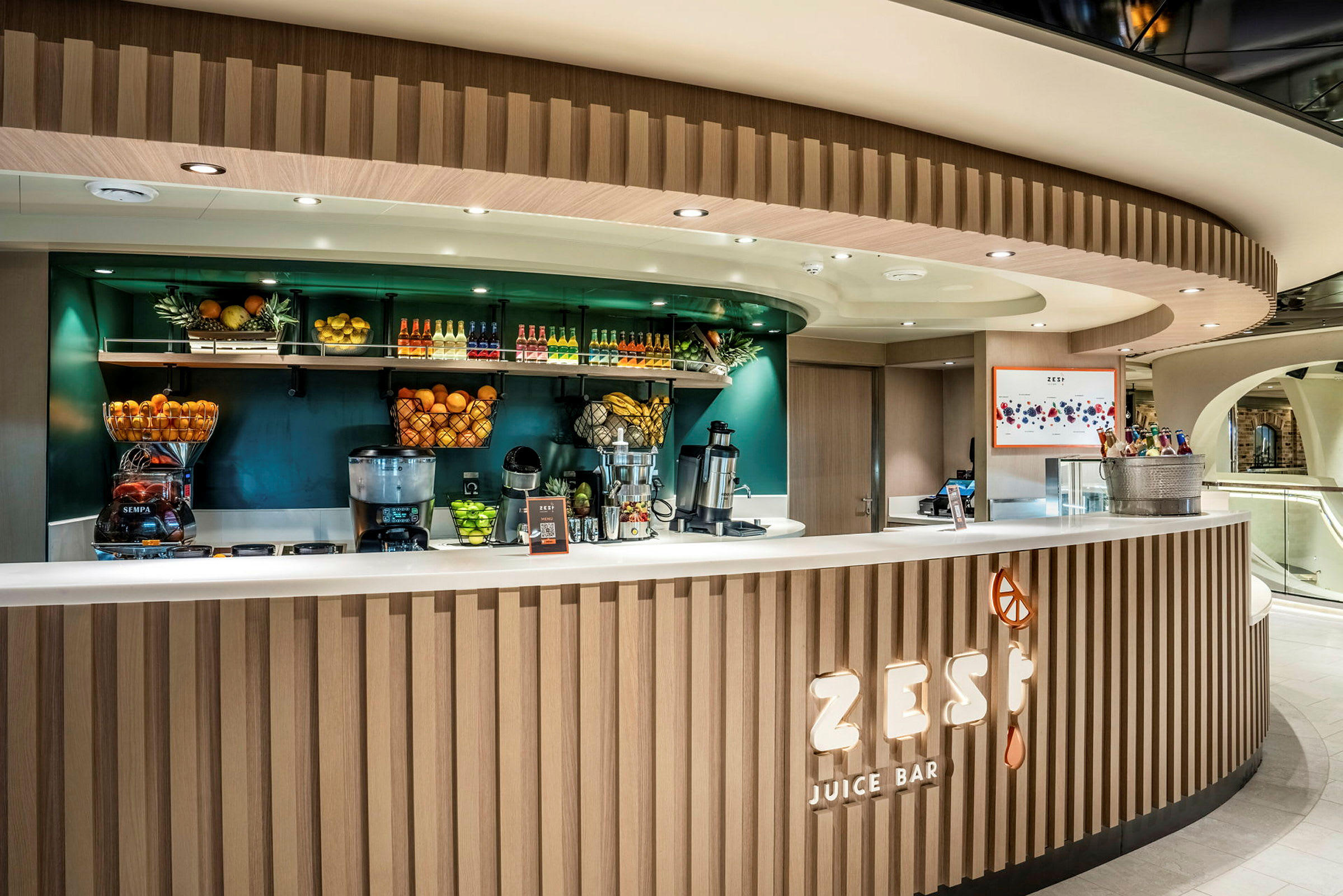 Billede af en juicebar med moderne design, fyldt med frisk frugt og juiceflasker. (AI-genereret tekst)