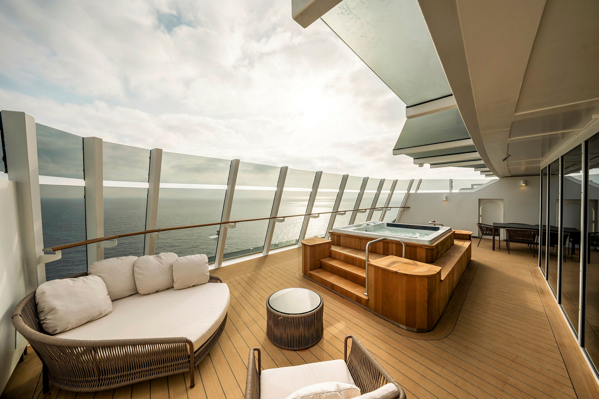 Privat terrasse med jacuzzi, siddepladser og udsigt over havet. (AI-genereret tekst)