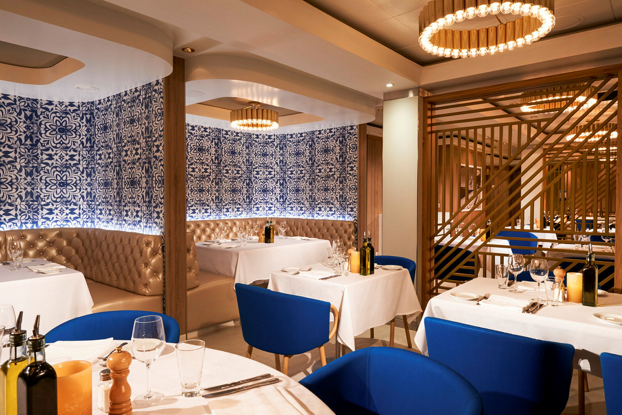 Restaurant med hvide duge, blå stole og dekorerede vægge. (AI-genereret tekst)