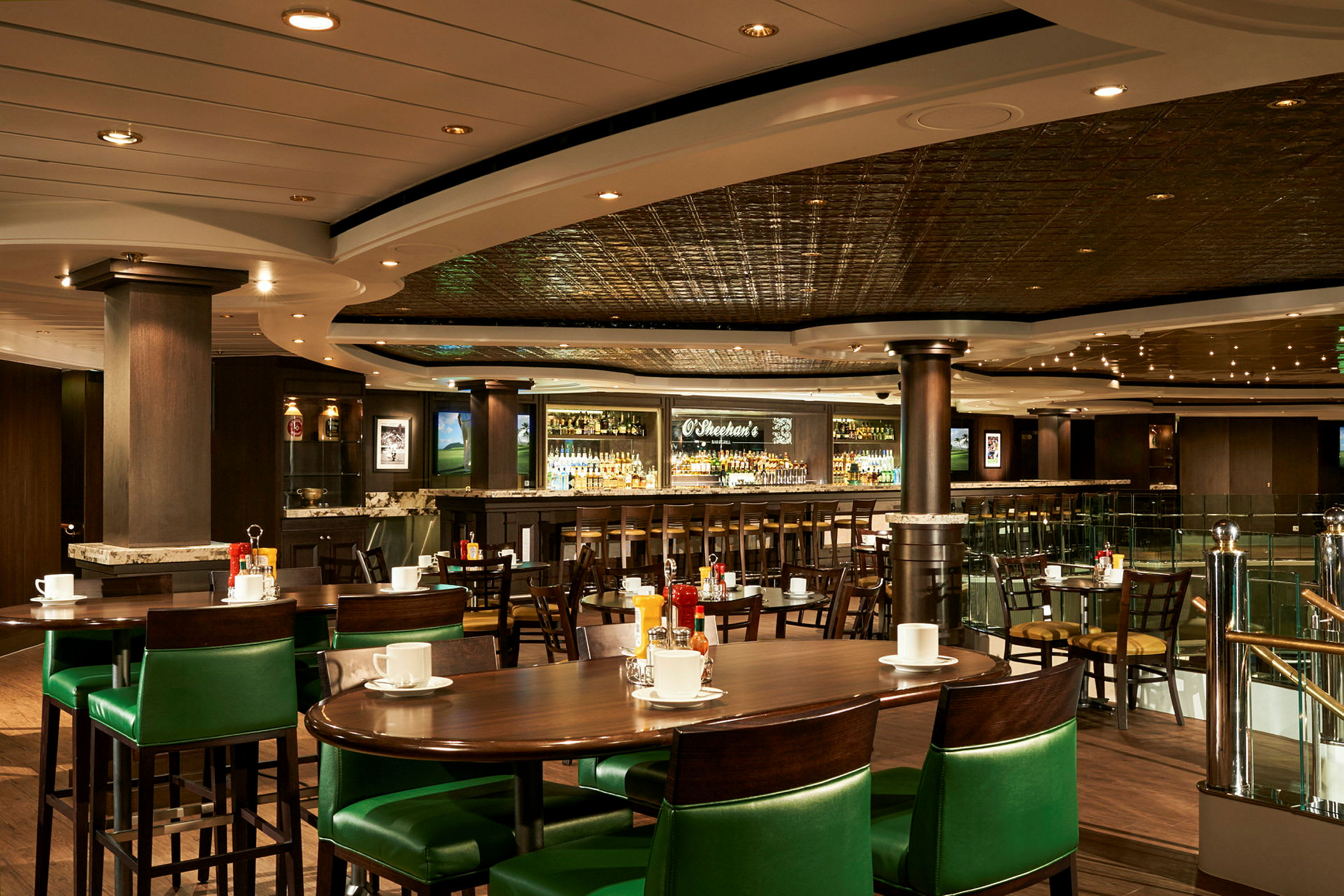 Billede af en restaurant med grønne stole, borde og en bar i baggrunden. (AI-genereret tekst)