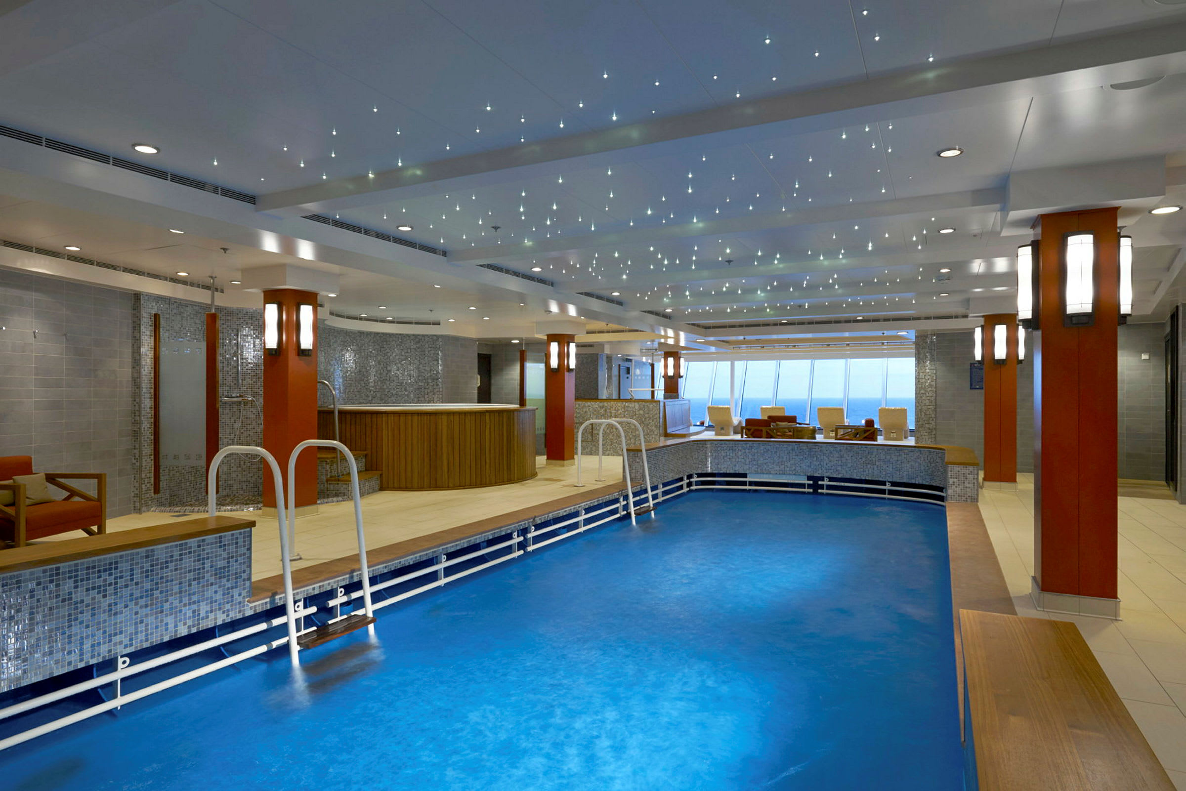 Indendørs swimmingpool med siddepladser og dekorativ belysning i loftet. (AI-genereret tekst)