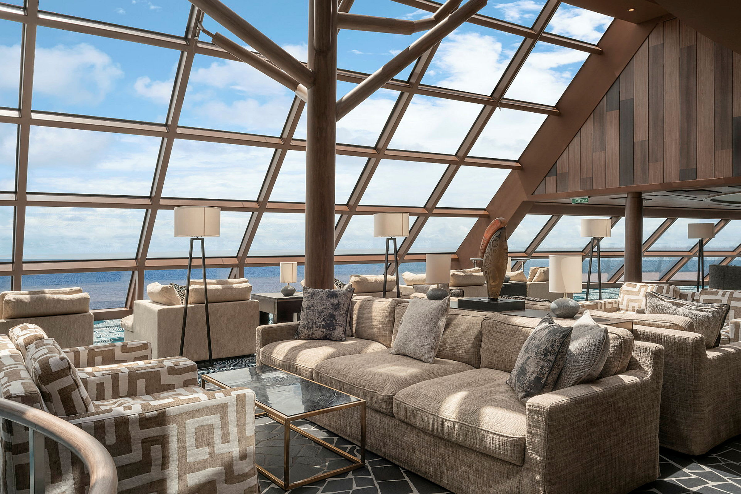 Lounge med moderne indretning og store panoramavinduer mod himmel og hav. (AI-genereret tekst)