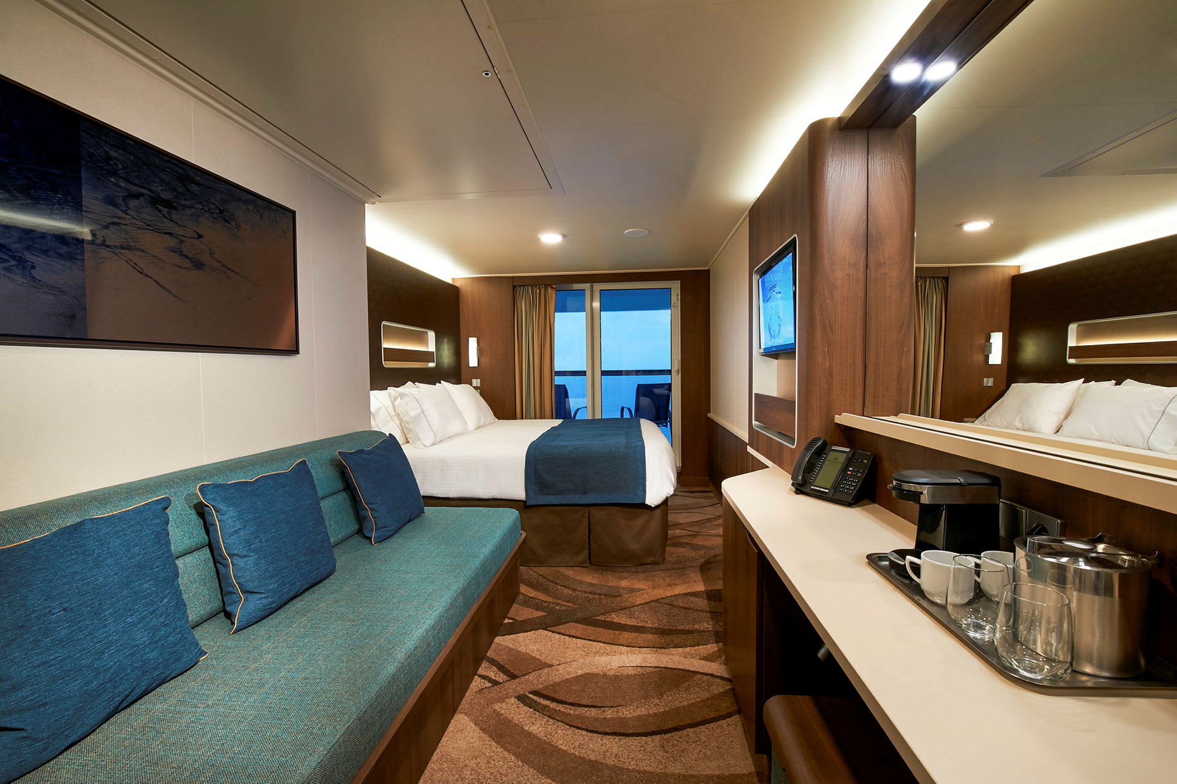 En hotelsuite med en seng, en siddegruppe og et skrivebord foran et spejl. (AI-genereret tekst)