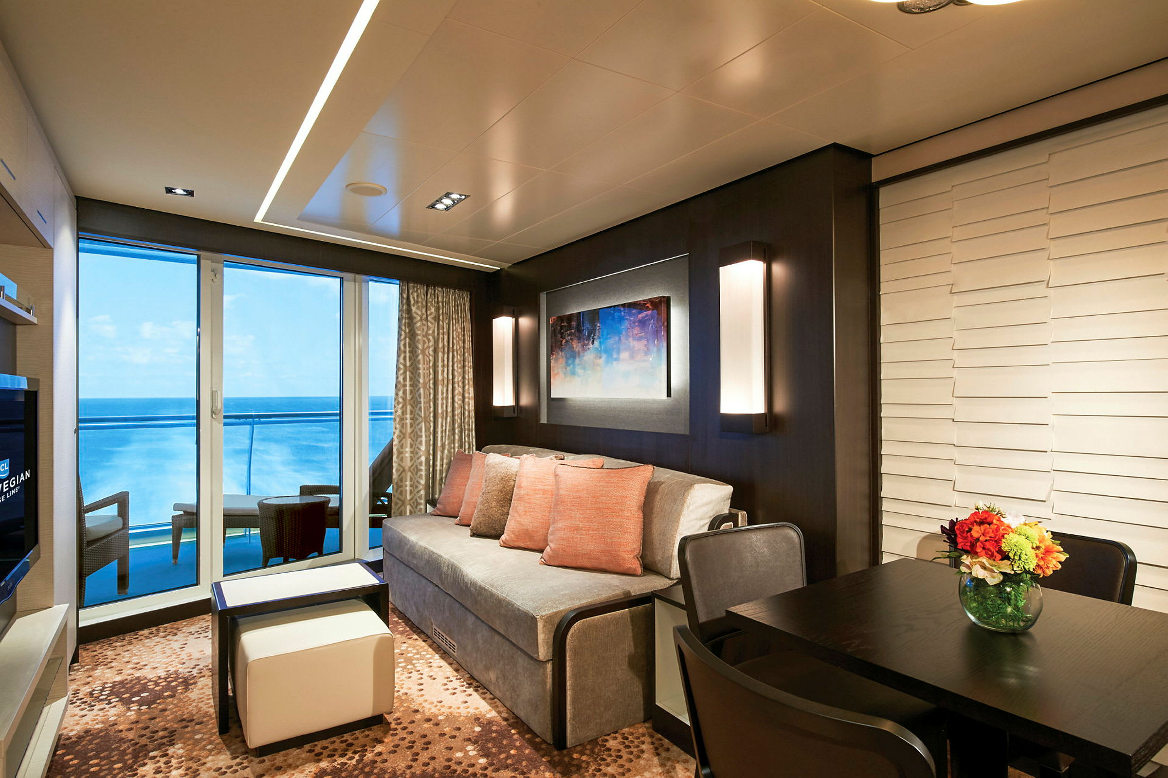 Moderne indrettet rum med sofa, bord og udsigt over havet. (AI-genereret tekst)