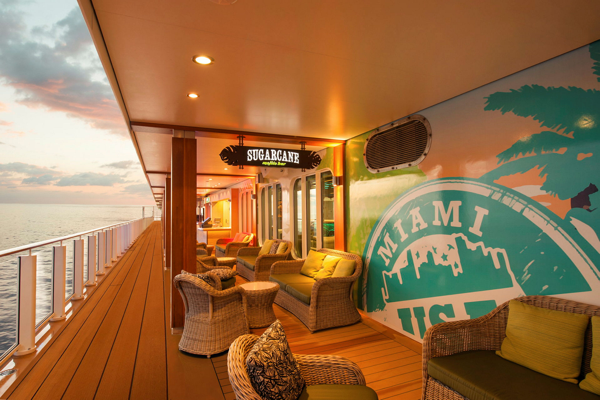 Udendørs lounge med rottingmøbler på et skib, ved siden af en væg med Miami USA-motiv. (AI-genereret tekst)