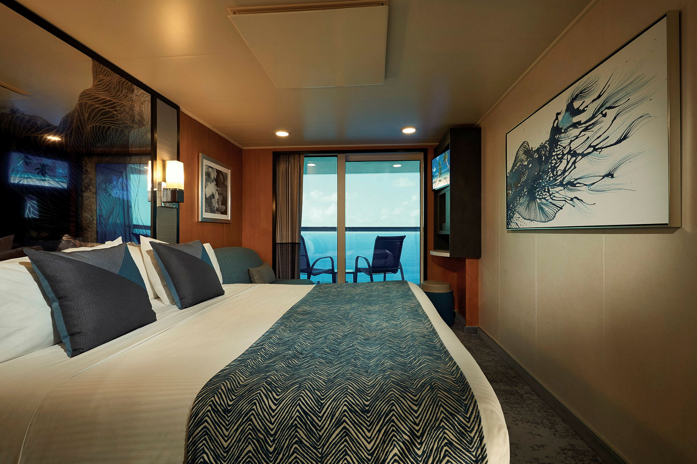 Et moderne hotelværelse med en dobbeltseng, kunst på væggene og en altan med udsigt over havet. (AI-genereret tekst)