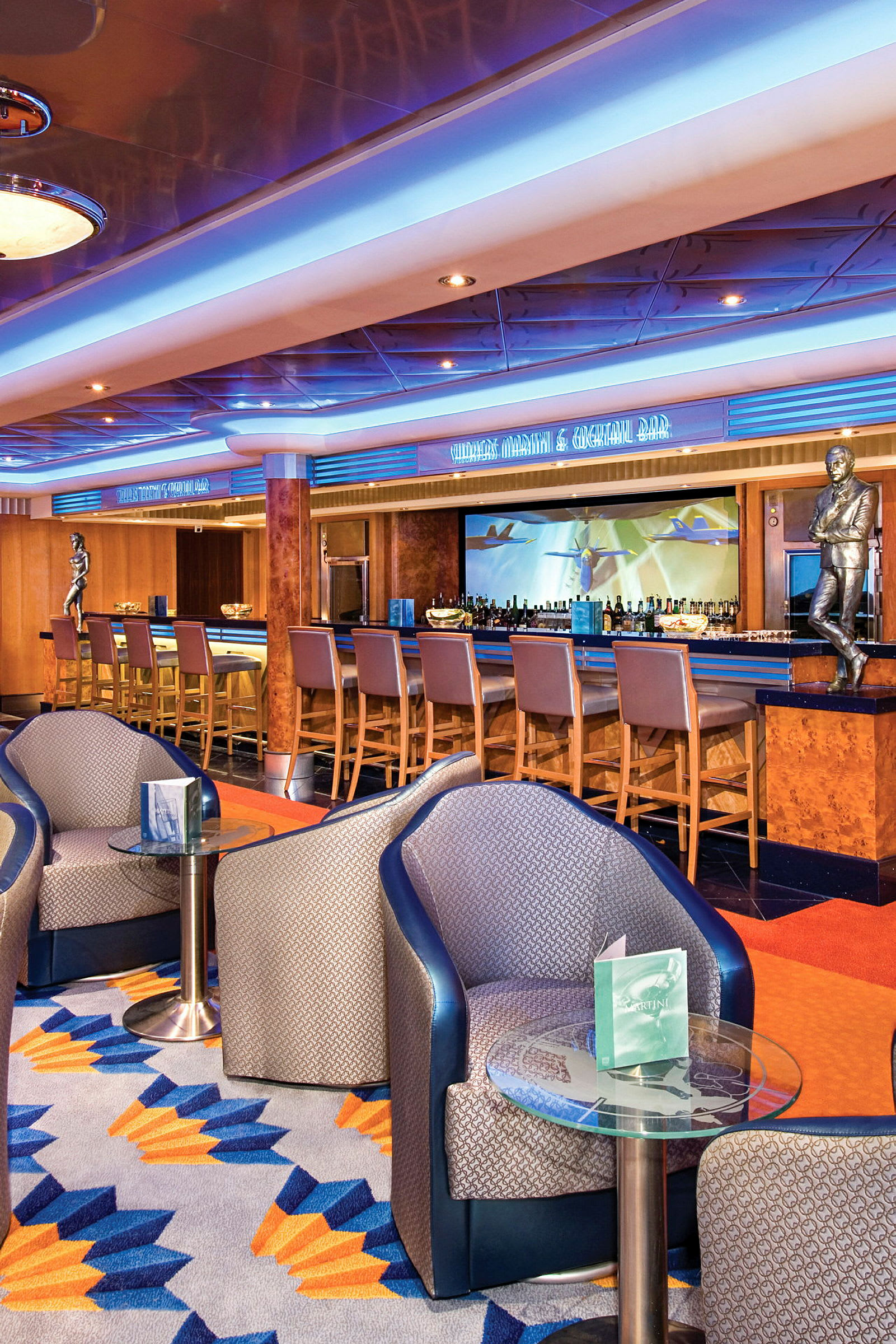 En elegant bar med høje stole og moderne indretning, herunder siddegrupper og et farverigt mønstret gulv. (AI-genereret tekst)