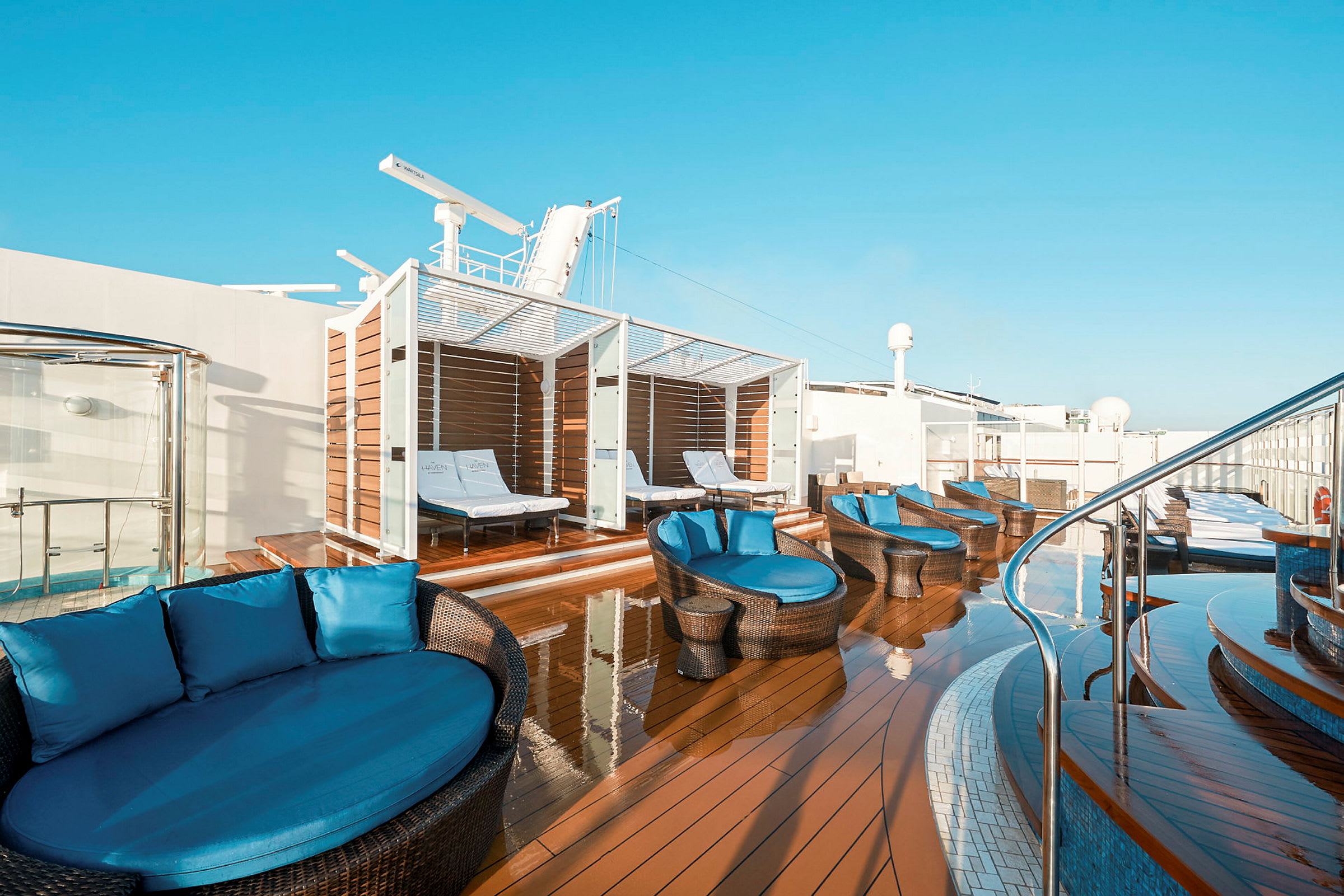 Billede af en solterrasse med solvogne og sofaer under tag. (AI-genereret tekst)