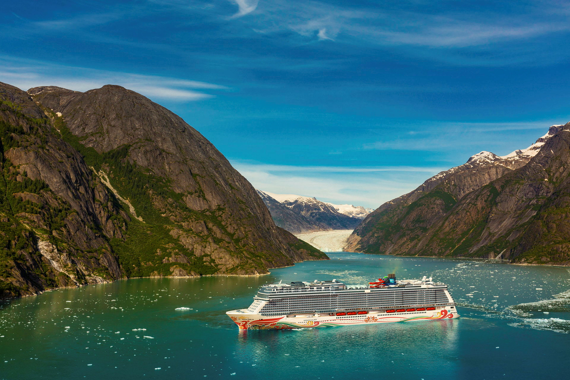 Krydstogtskib i fjord med omkringliggende bjerge og gletsjer i baggrunden. (AI-genereret tekst)