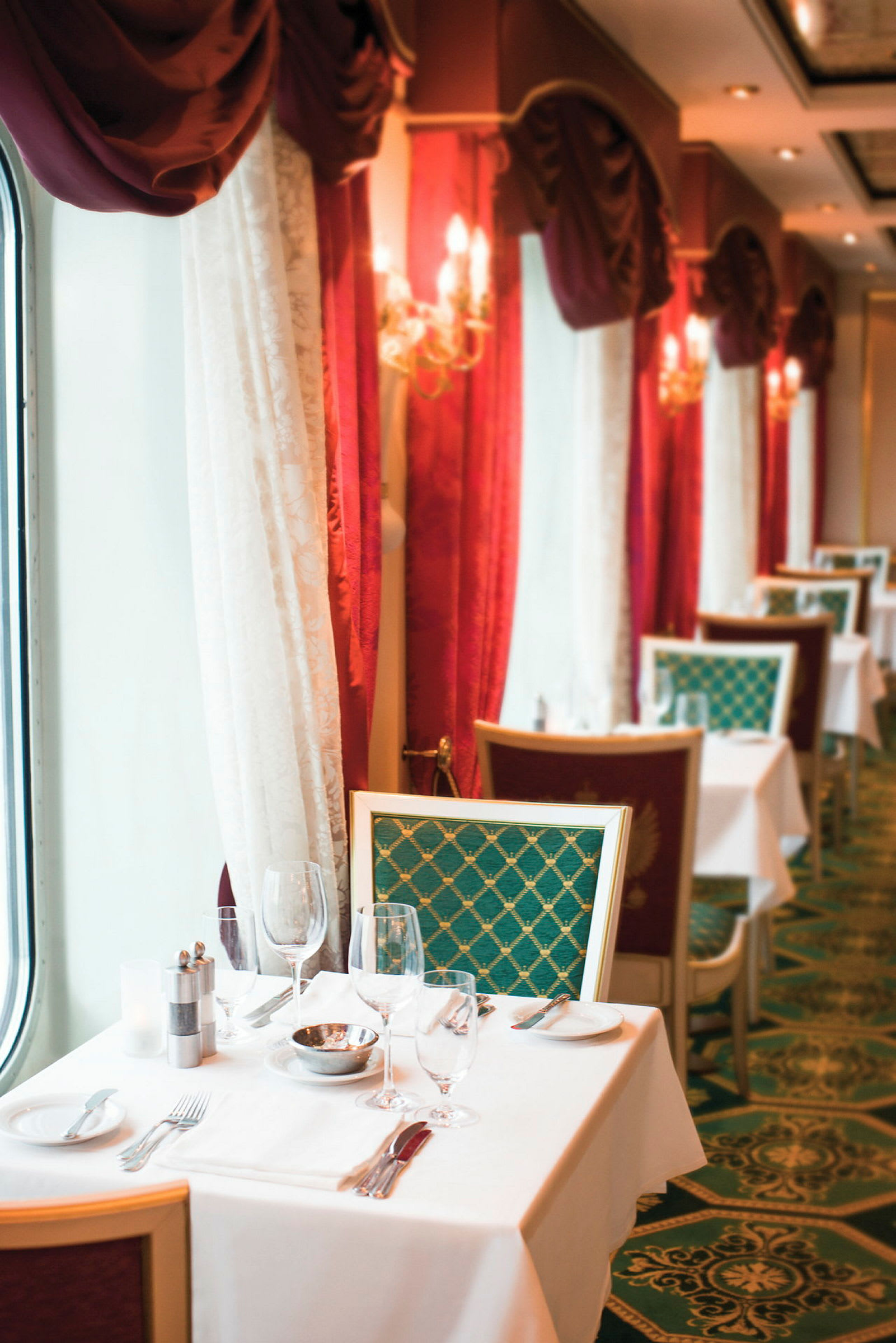 En elegant restaurant med dækkede borde og røde gardiner. (AI-genereret tekst)