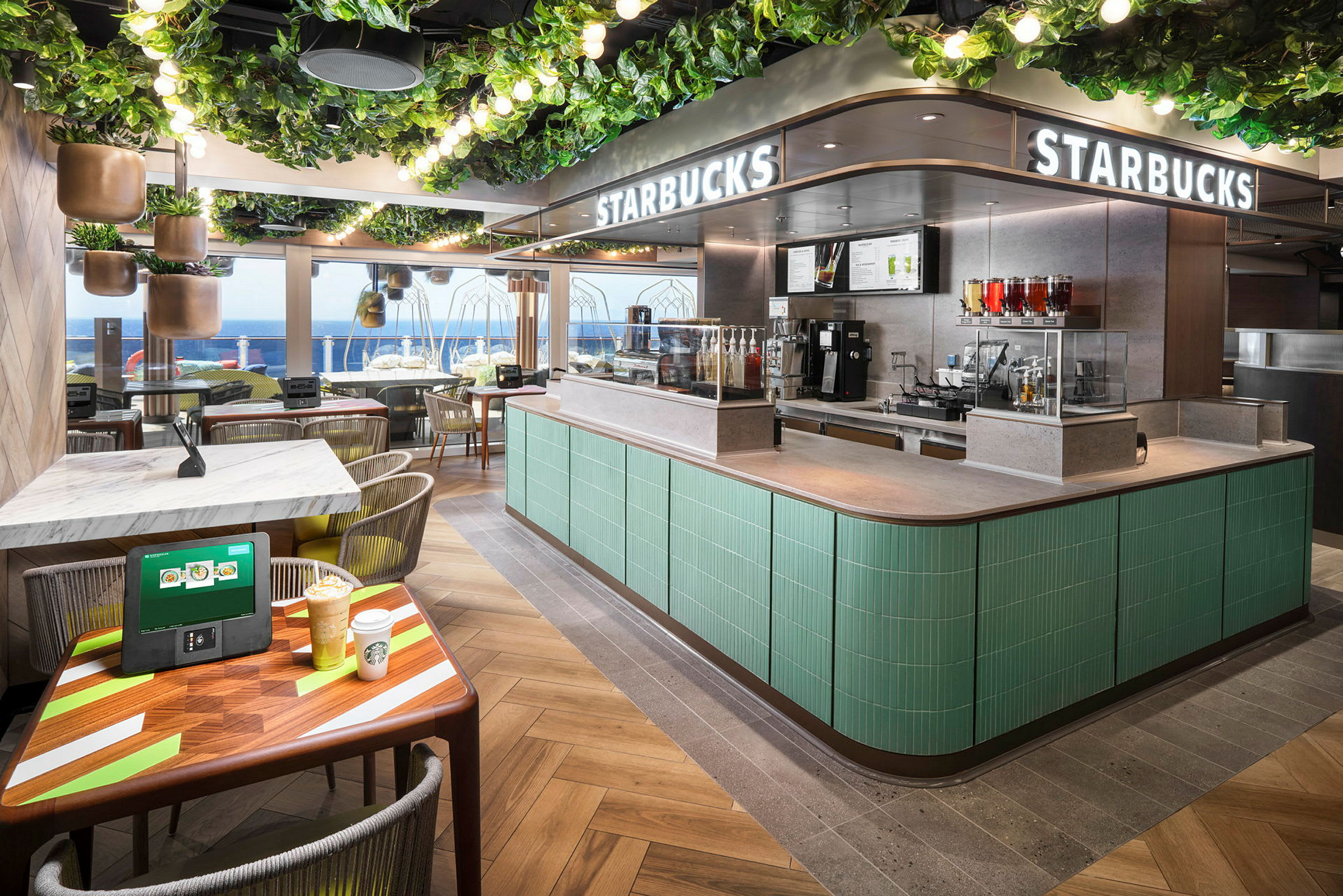En Starbucks-butik med havudsigt, grønt interiør og siddepladser. (AI-genereret tekst)