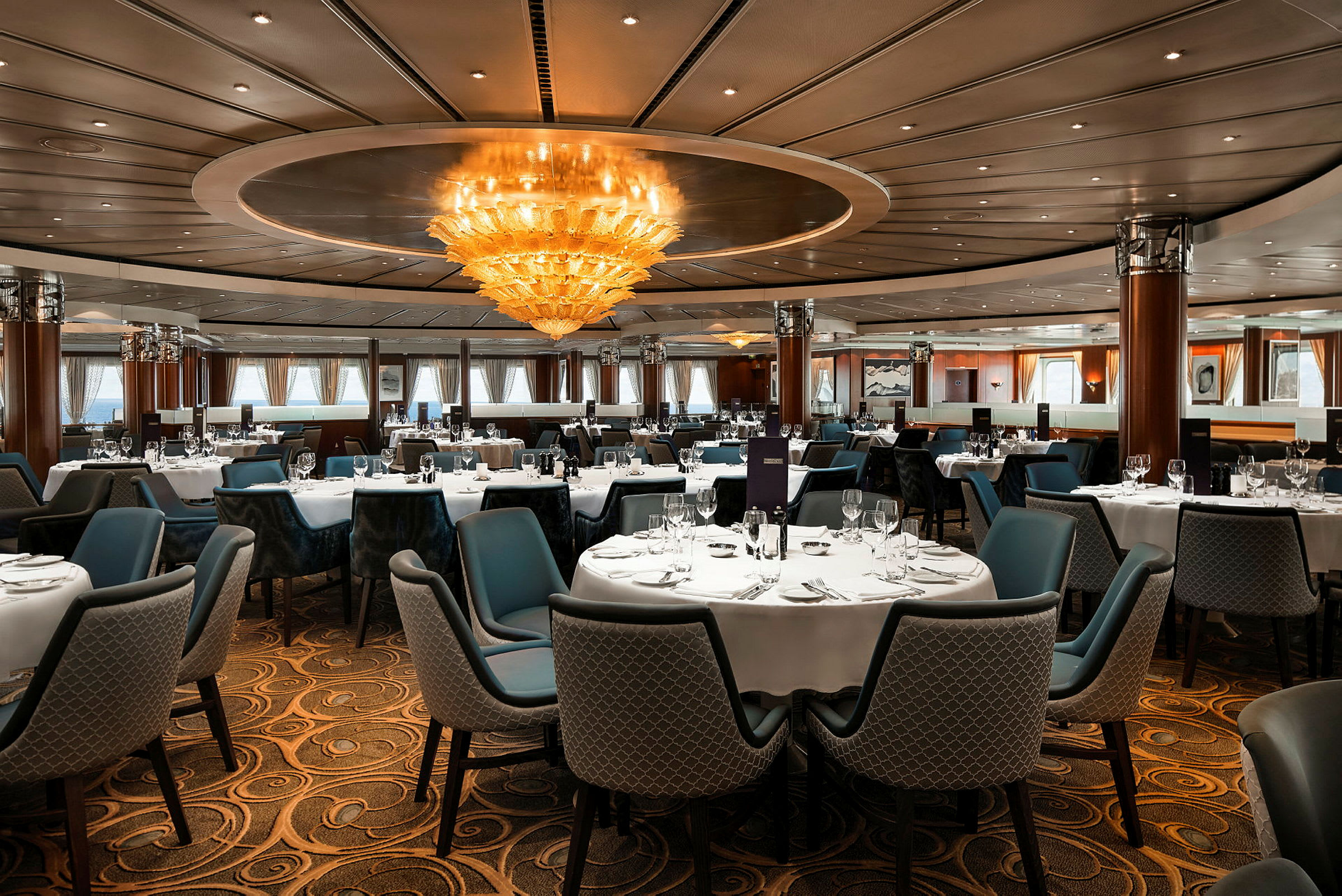 En elegant restaurant med dækkede borde og en stor loftlampe. (AI-genereret tekst)