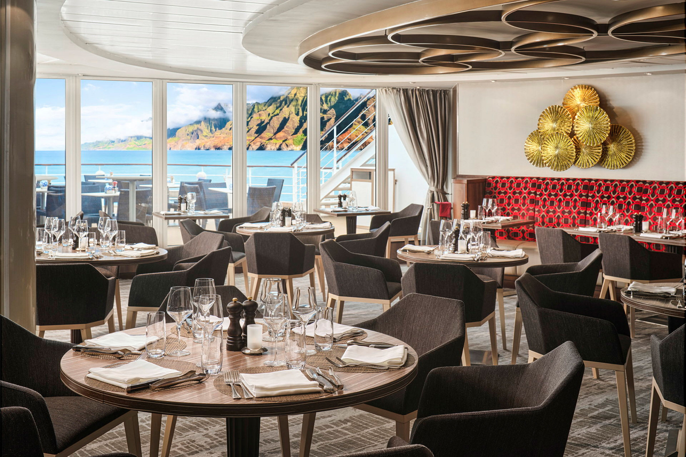 Restaurant med dækkede runde borde ved store vinduer med havudsigt. (AI-genereret tekst)