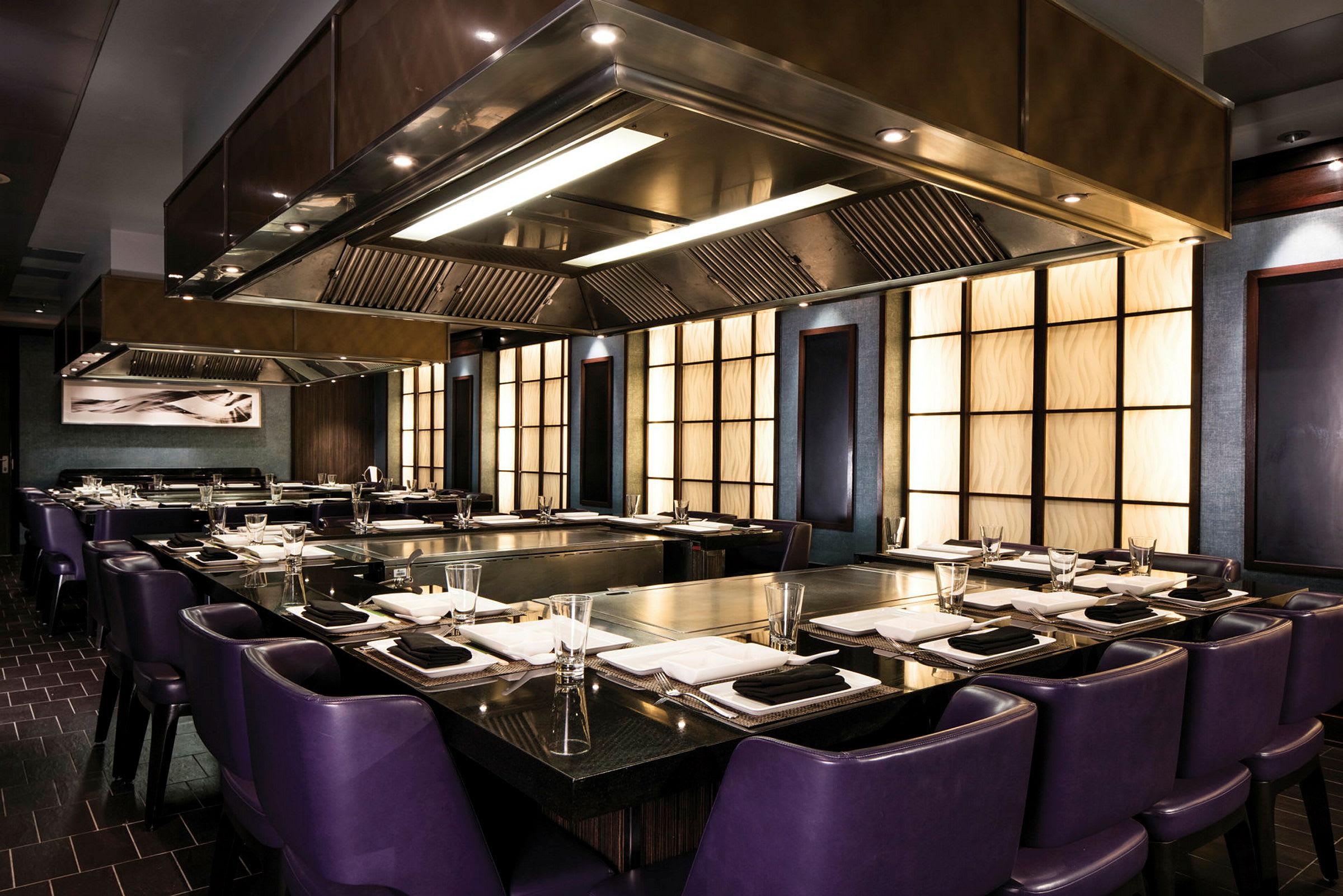 En elegant restaurant med lilla stole og moderne køkkenindretning. (AI-genereret tekst)