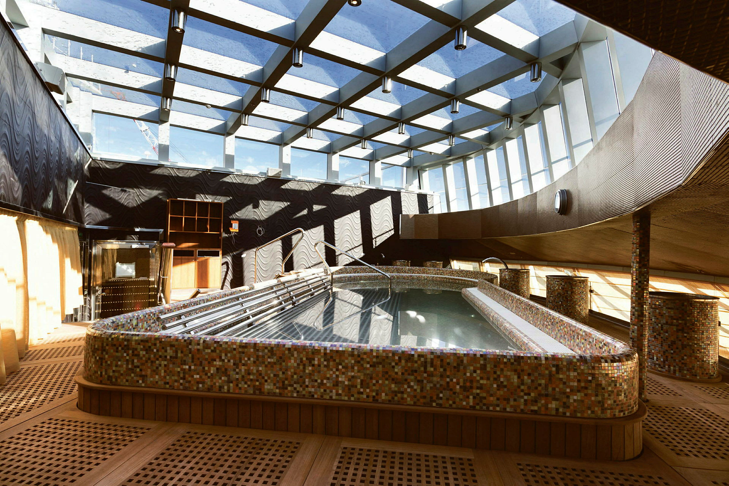 En indendørs pool med ovenlysvinduer og moderne arkitektonisk design. (AI-genereret tekst)