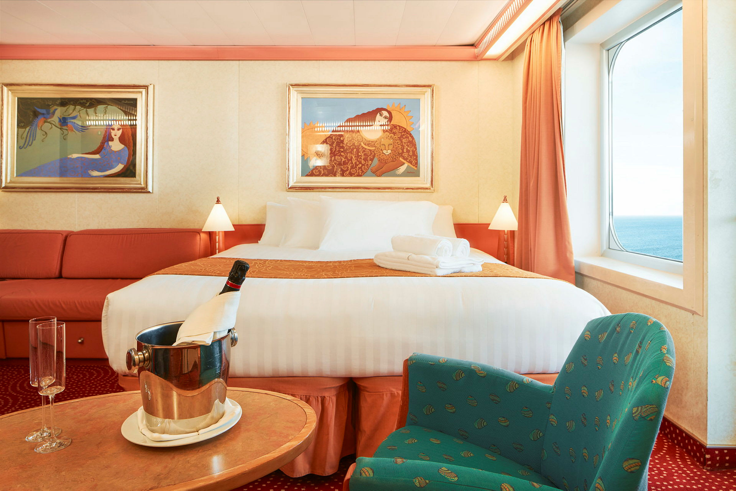En luksuriøs hotelsuite med stor seng, siddeområde og havudsigt. (AI-genereret tekst)