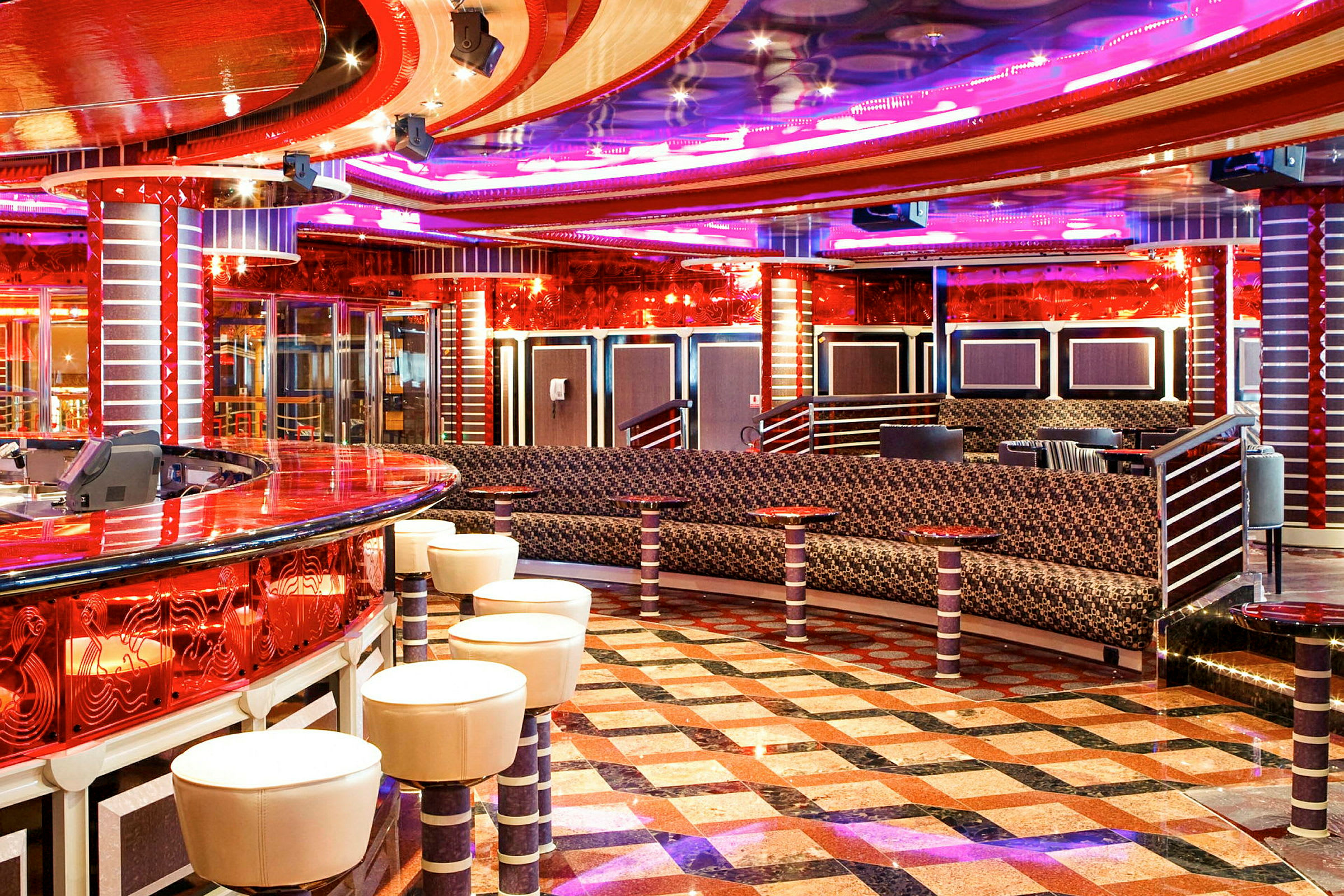 Interiør af en farverig lounge med bar, siddepladser og mønstret gulv. (AI-genereret tekst)