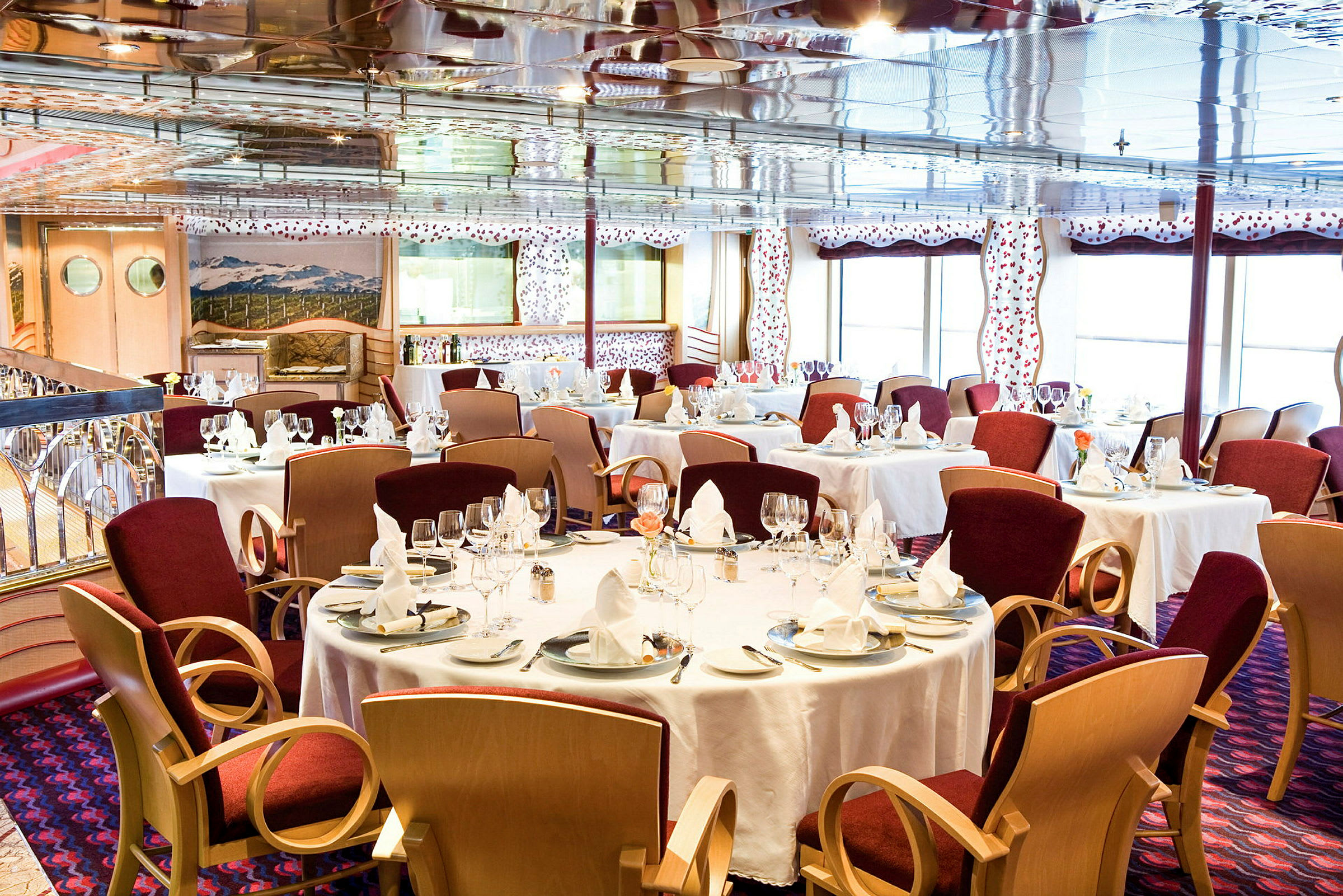 En elegant restaurant med dækkede borde og røde stole. (AI-genereret tekst)