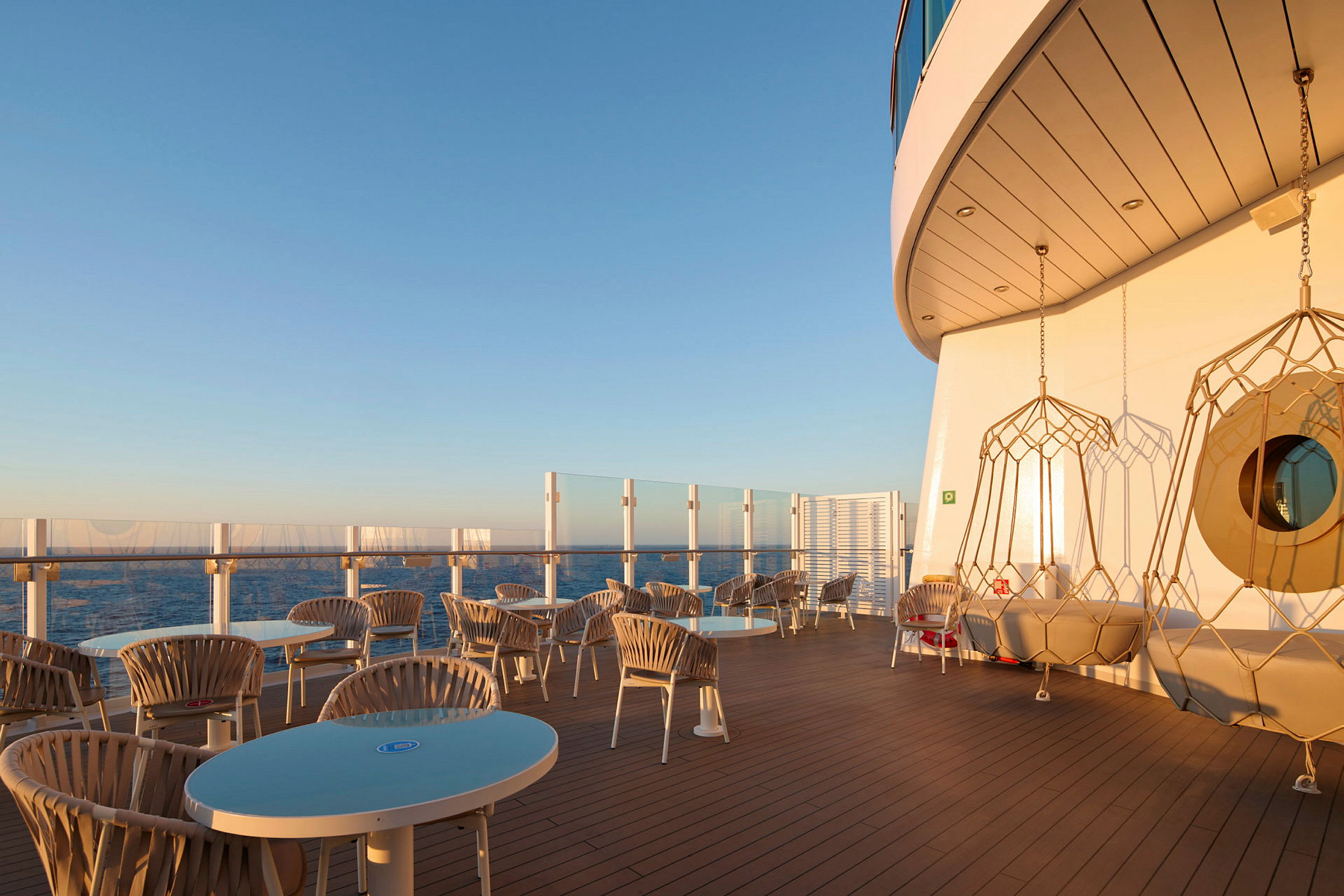 Solbeskinnet terrasse med siddepladser og havudsigt. (AI-genereret tekst)