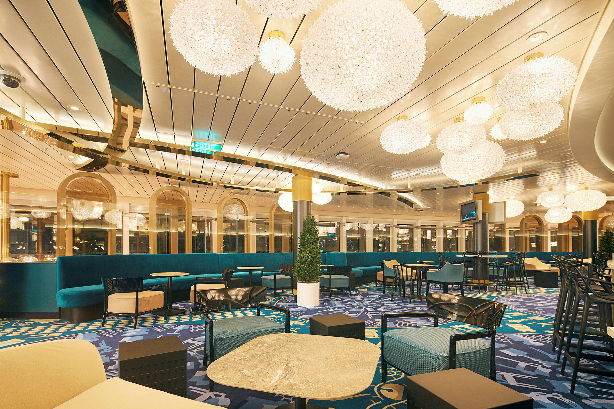 En elegant lounge med siddegrupper og store lysekroner. (AI-genereret tekst)