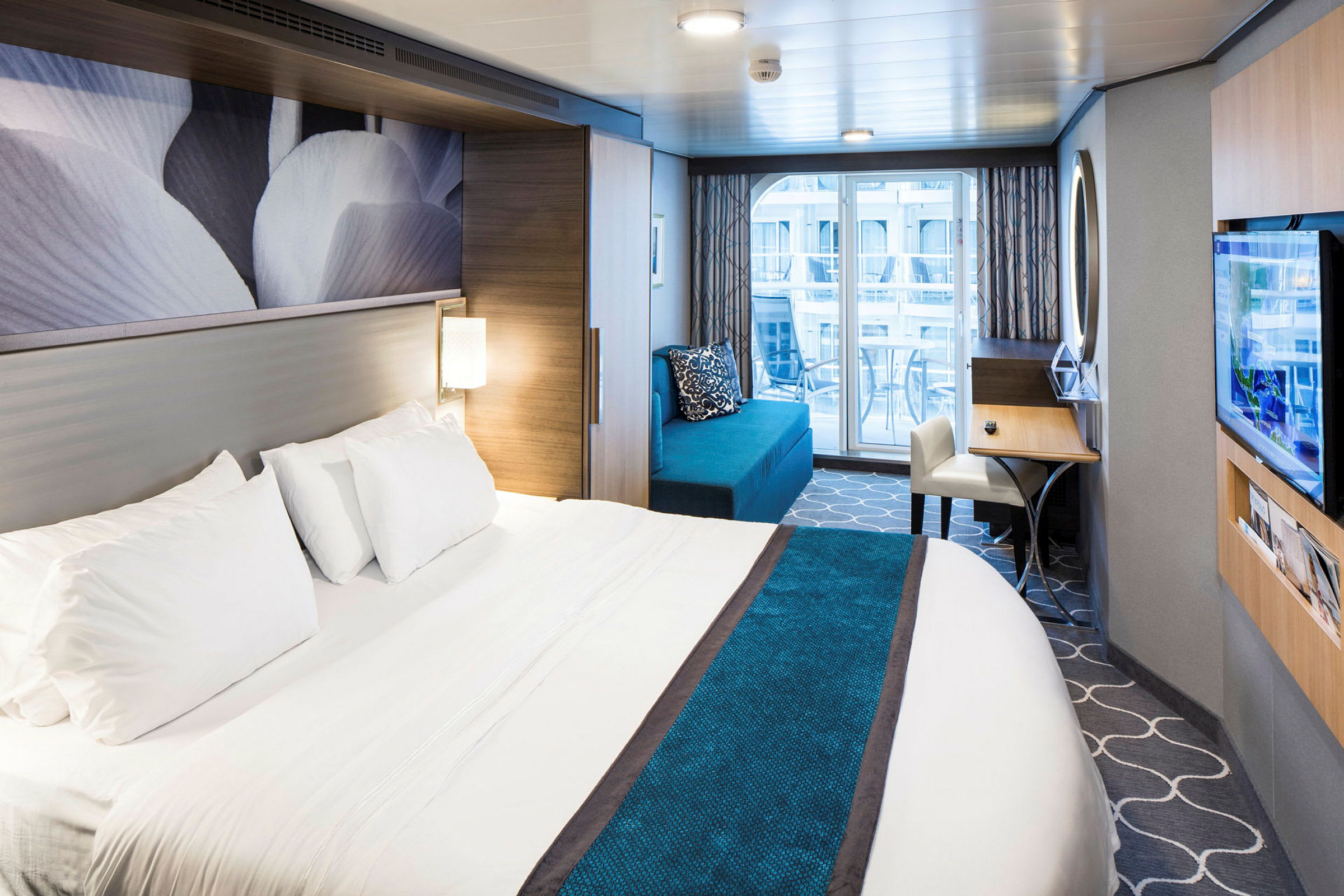 Hotelværelse med en stor seng, sofa, skrivebord og altan. (AI-genereret tekst)