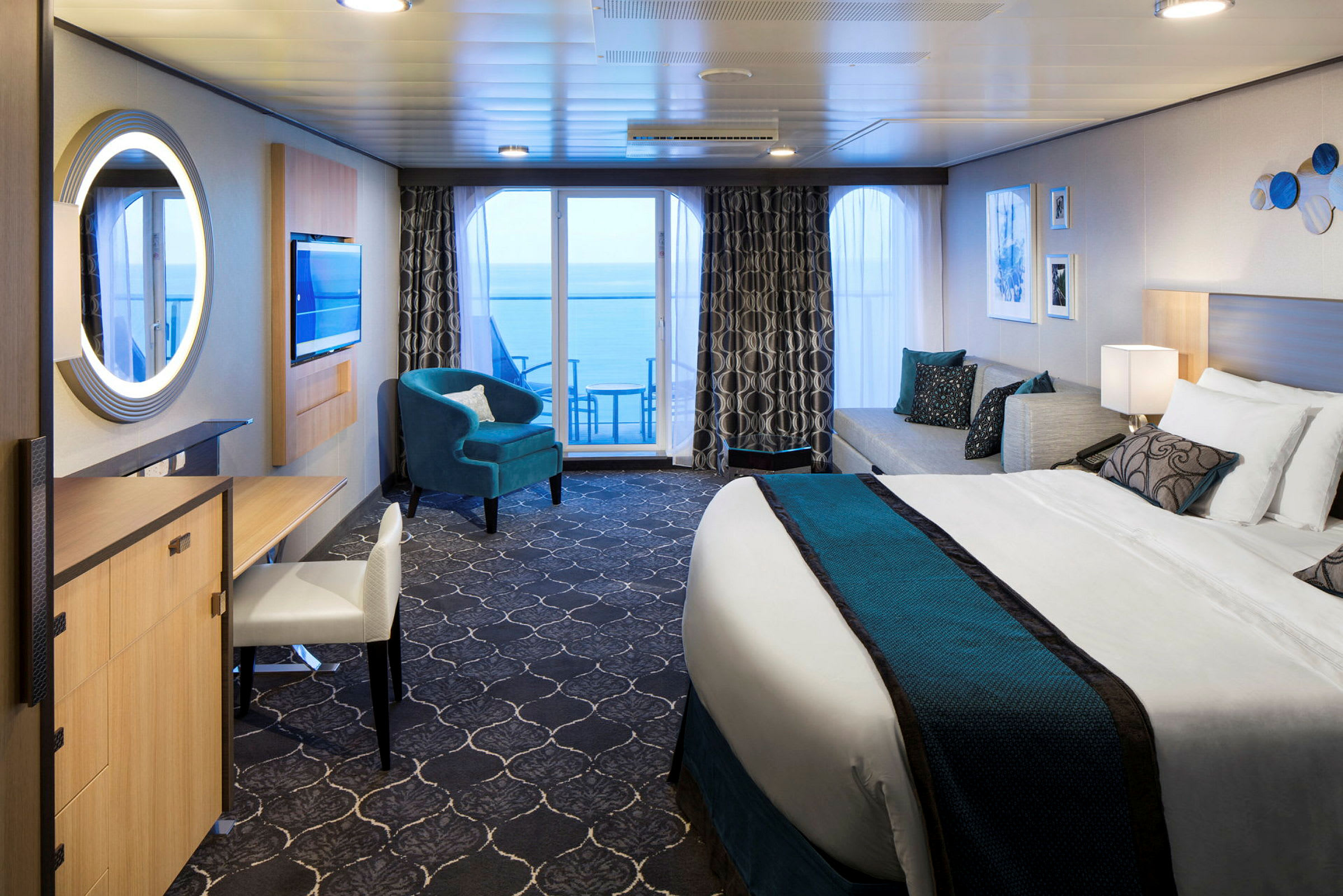 Et moderne hotelværelse med stor seng, siddeområde og altan med havudsigt. (AI-genereret tekst)