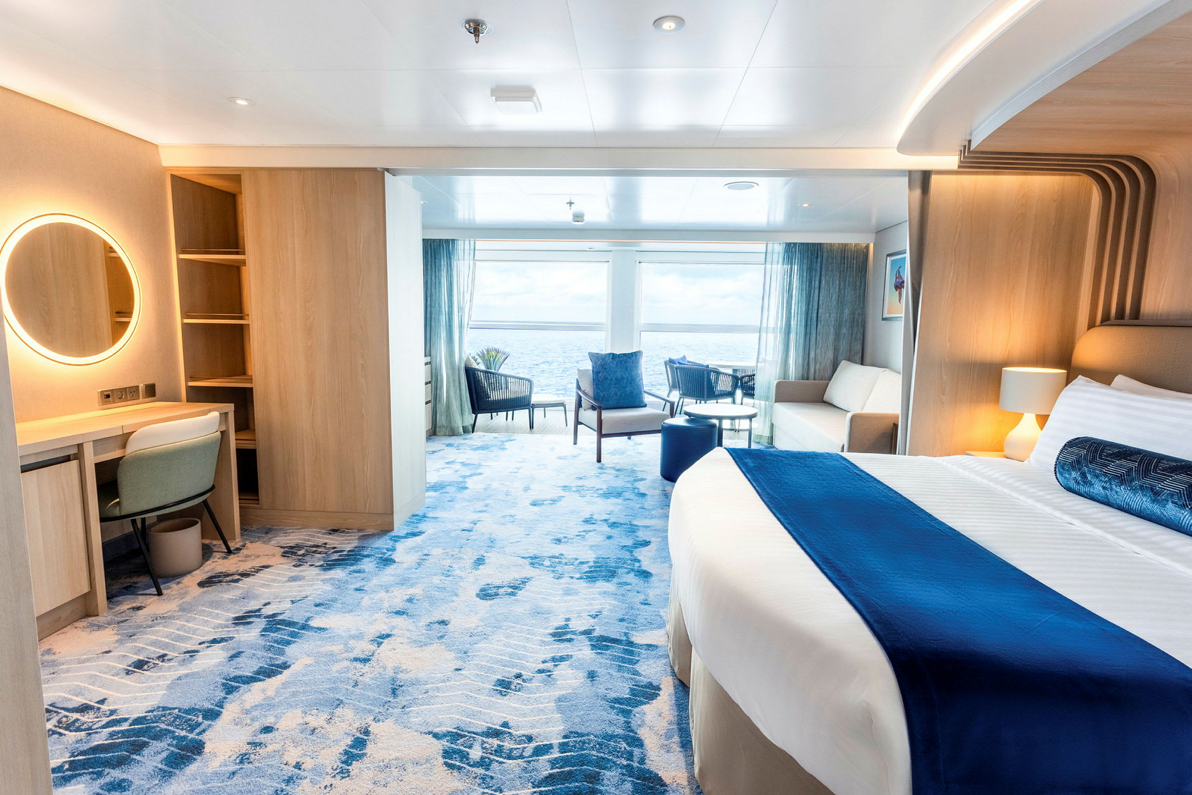 Hotelværelse med havudsigt, møbleret med seng, sofa og skrivebord. (AI-genereret tekst)