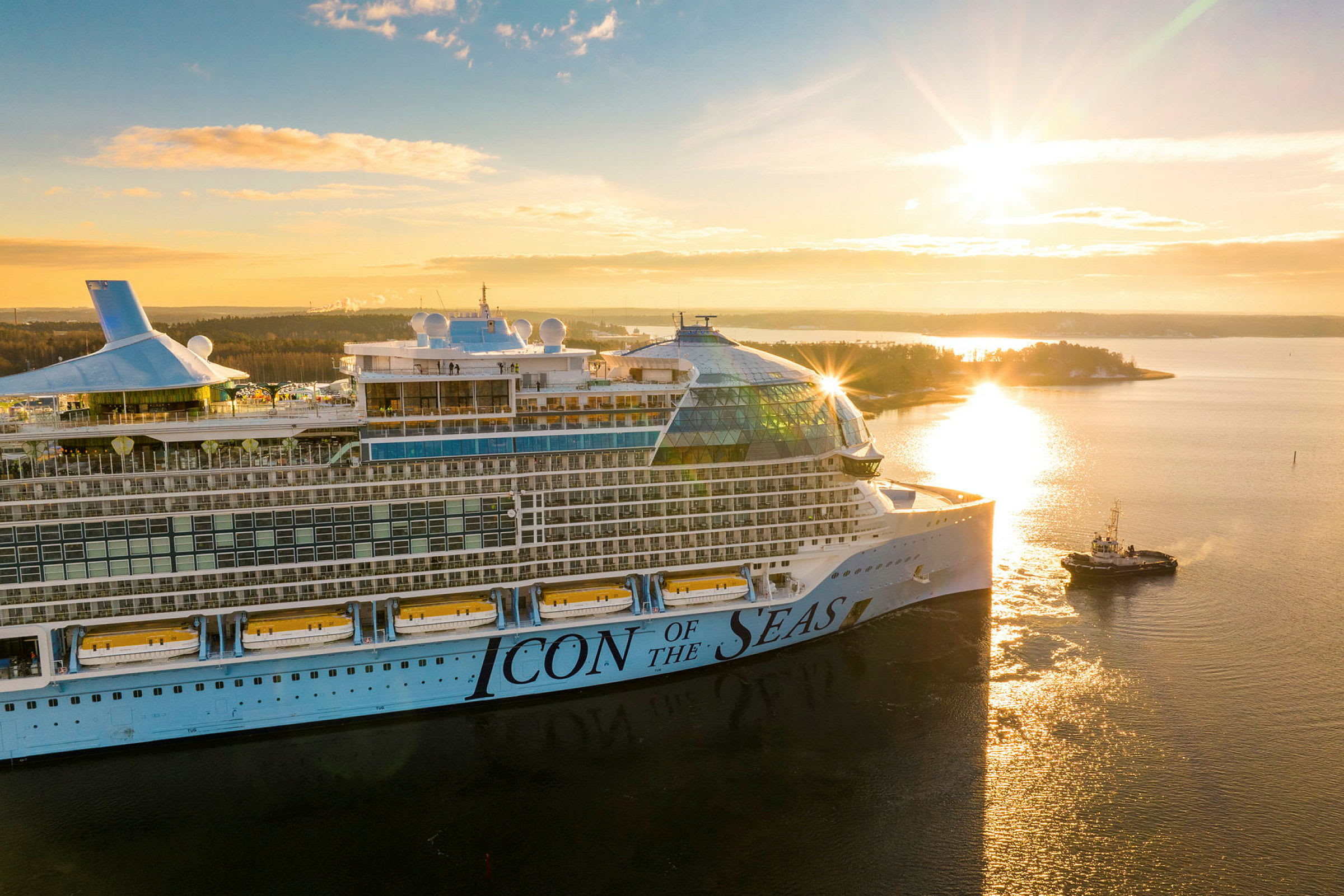 Et krydstogtskib med teksten 'Icon of the Seas' på siden ses i solopgangen over en sø. (AI-genereret tekst)