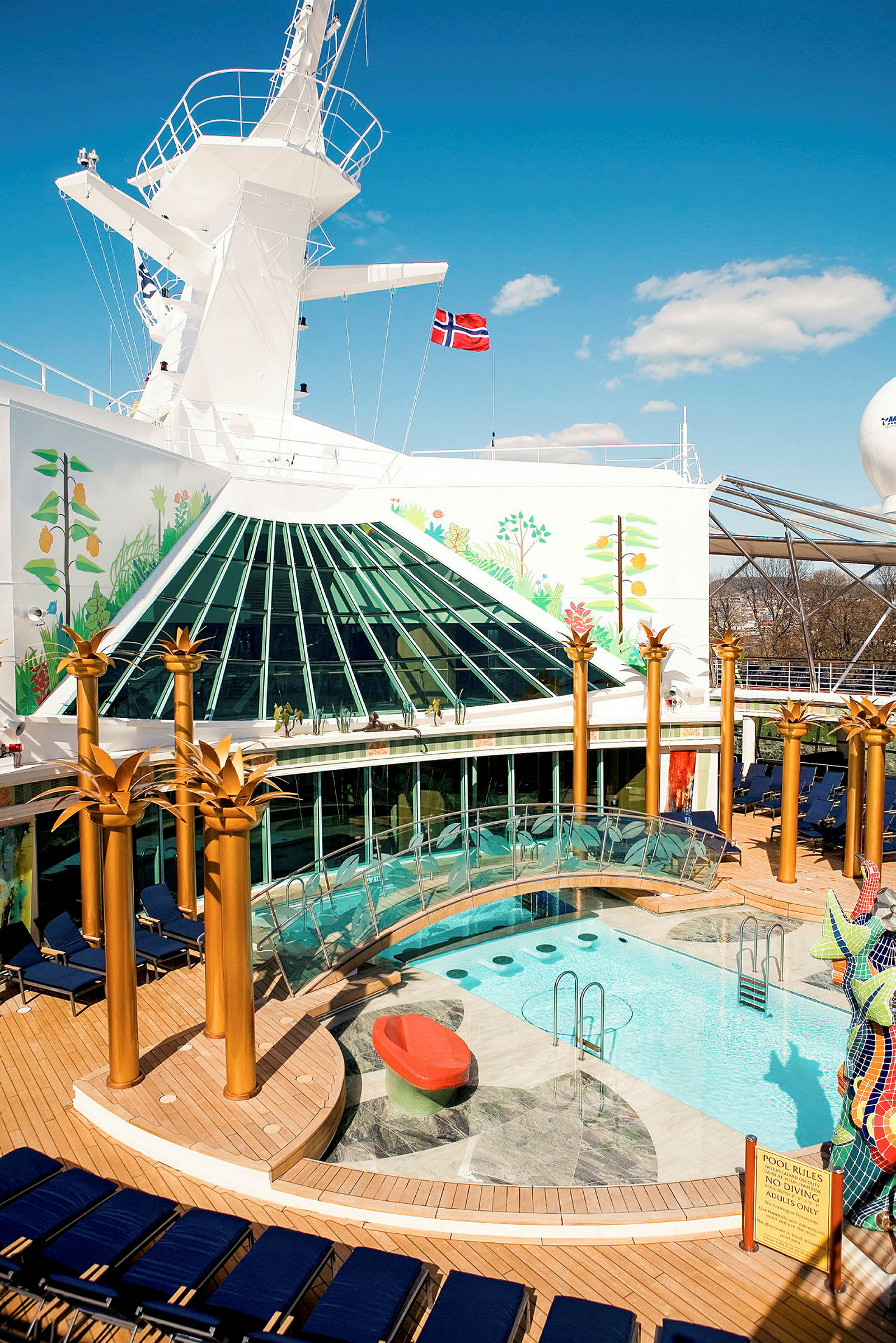 Billede af et krydstogtskibs poolområde med trædæk, swimmingpool og dekoration. (AI-genereret tekst)