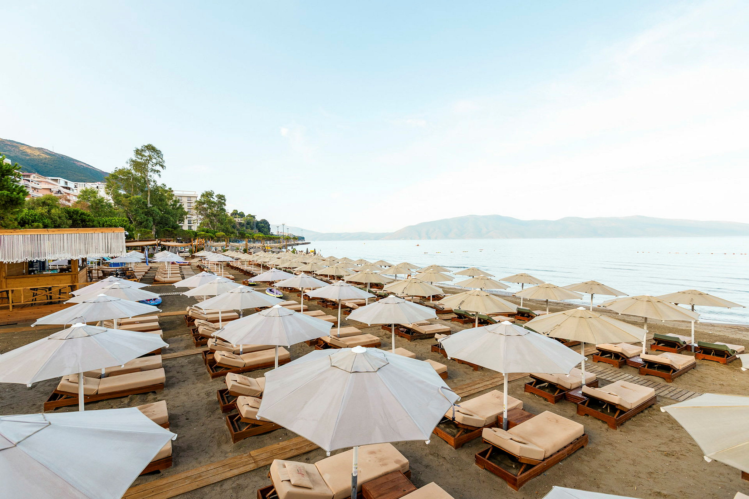 Solstole med parasoller på en strand med havudsigt. (AI-genereret tekst)