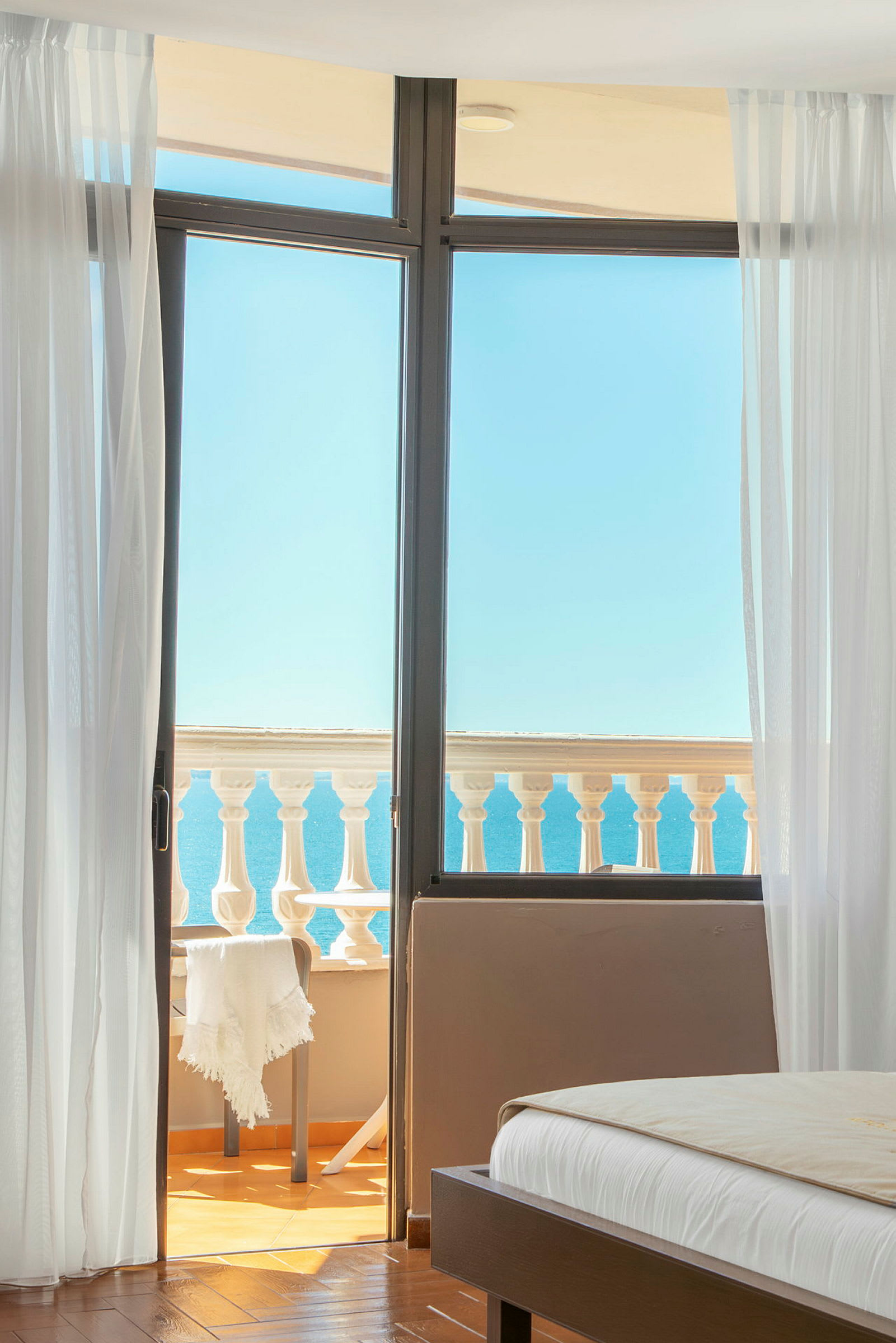 Udsigt fra et soveværelse mod en balkon med havet i baggrunden. (AI-genereret tekst)