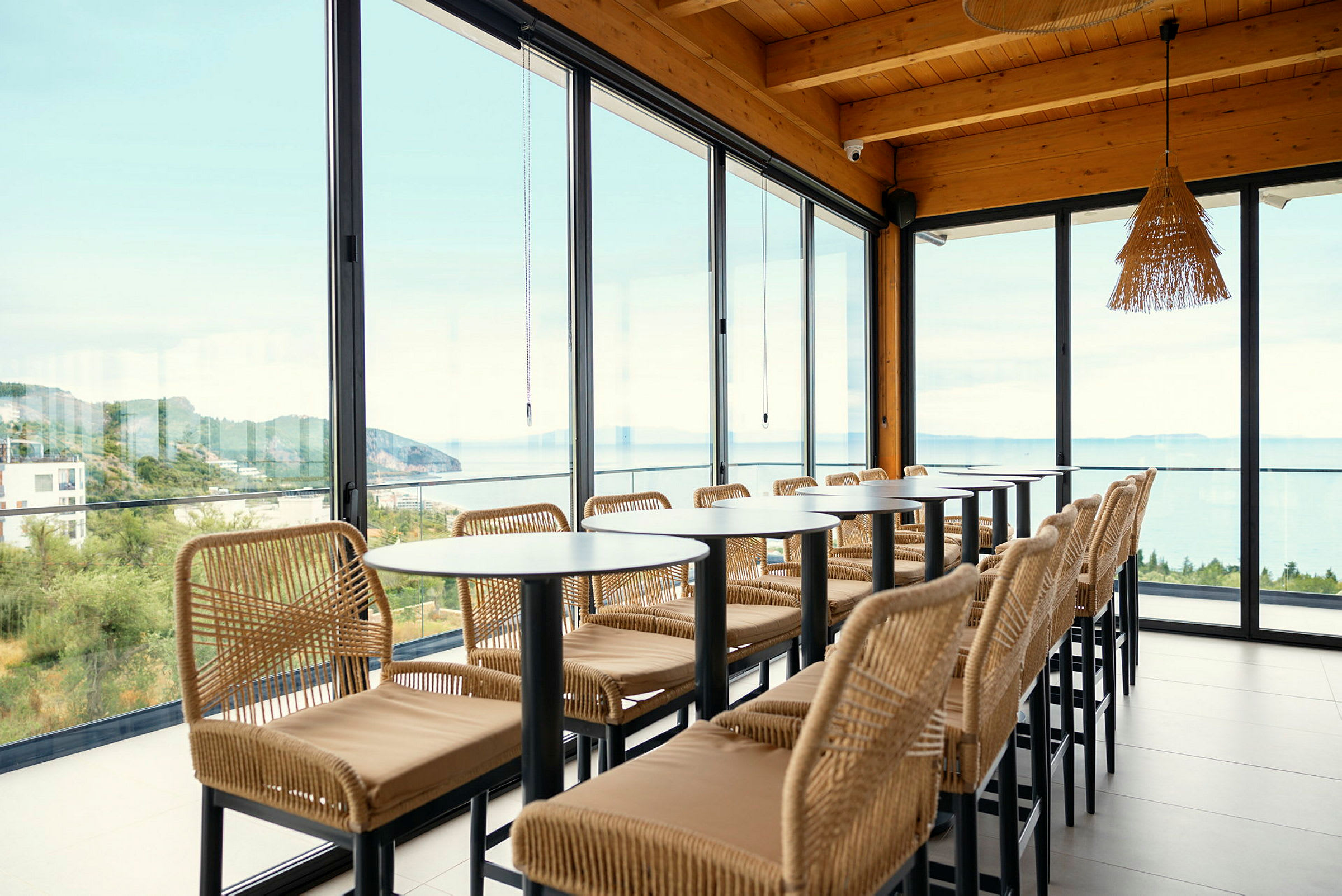 Restaurant med store glasvinduer og udsigt over havet. (AI-genereret tekst)