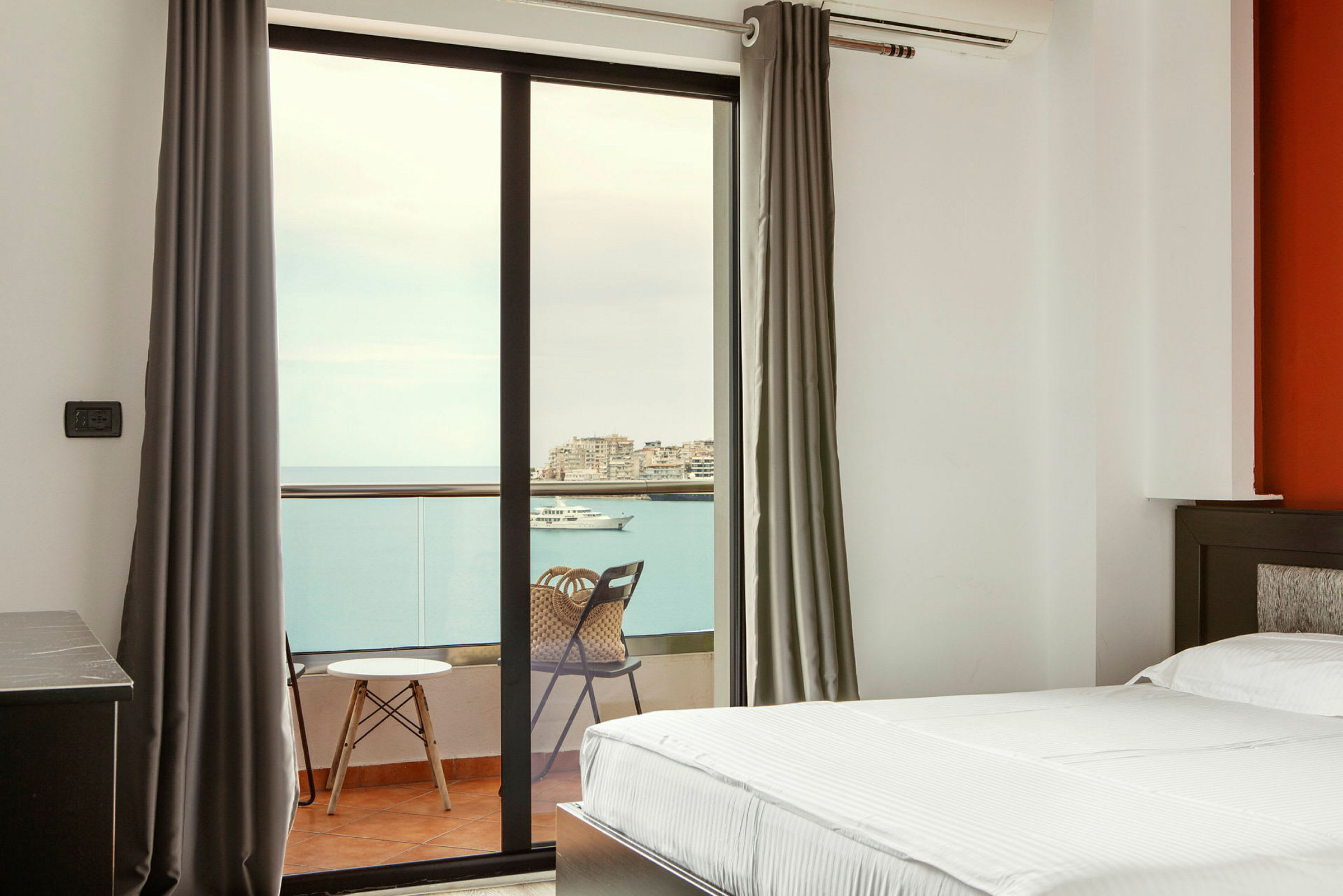 Hotelværelse med altan og udsigt over havet. (AI-genereret tekst)