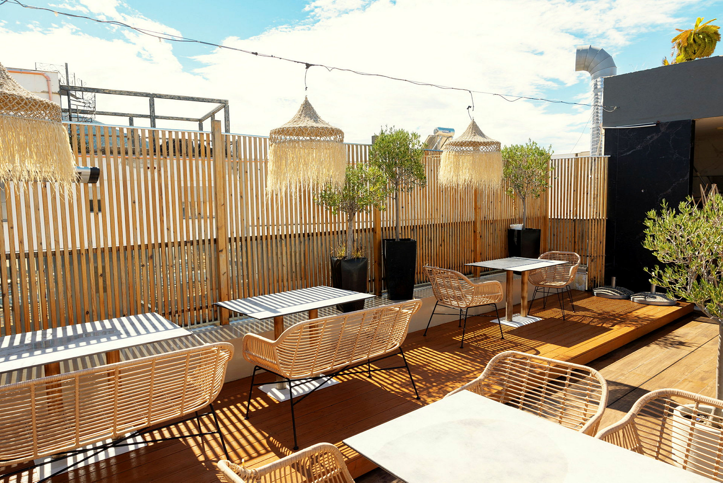 Udendørs terrasse med borde og siddepladser samt naturdekorationer. (AI-genereret tekst)