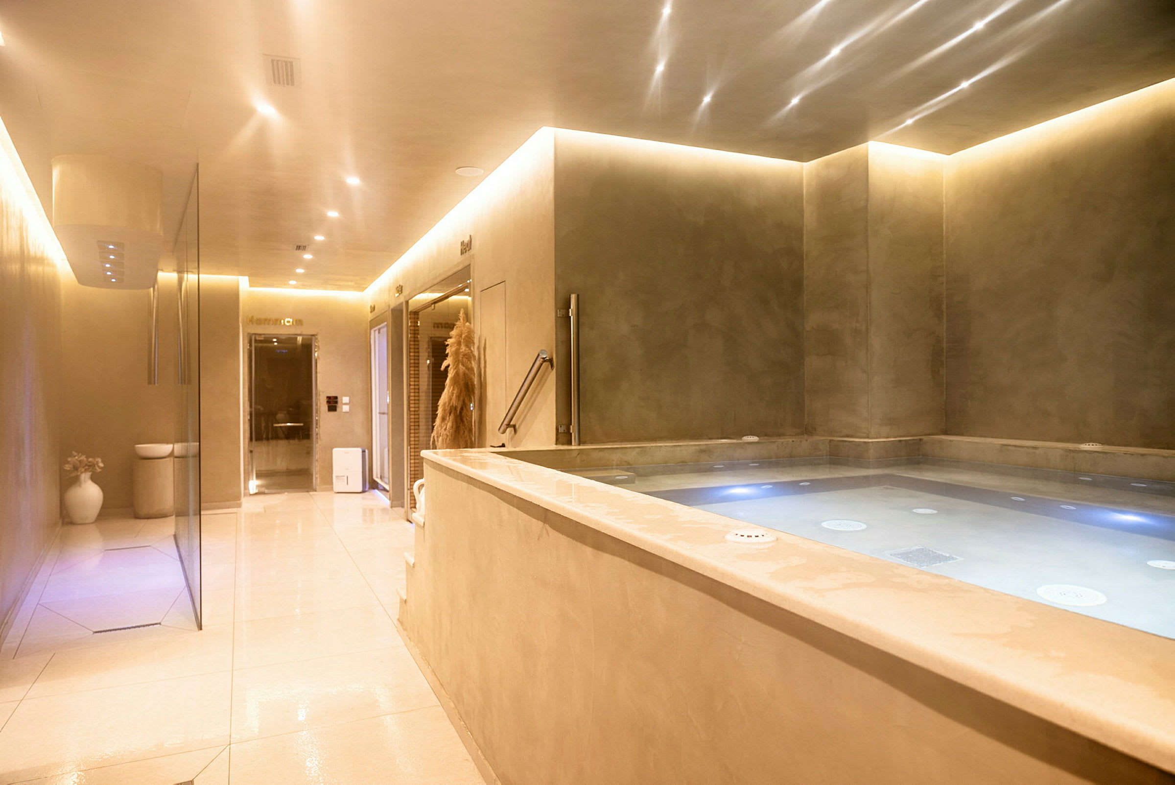 En afslappet indendørsmiljø med en jacuzzi og belysning. (AI-genereret tekst)