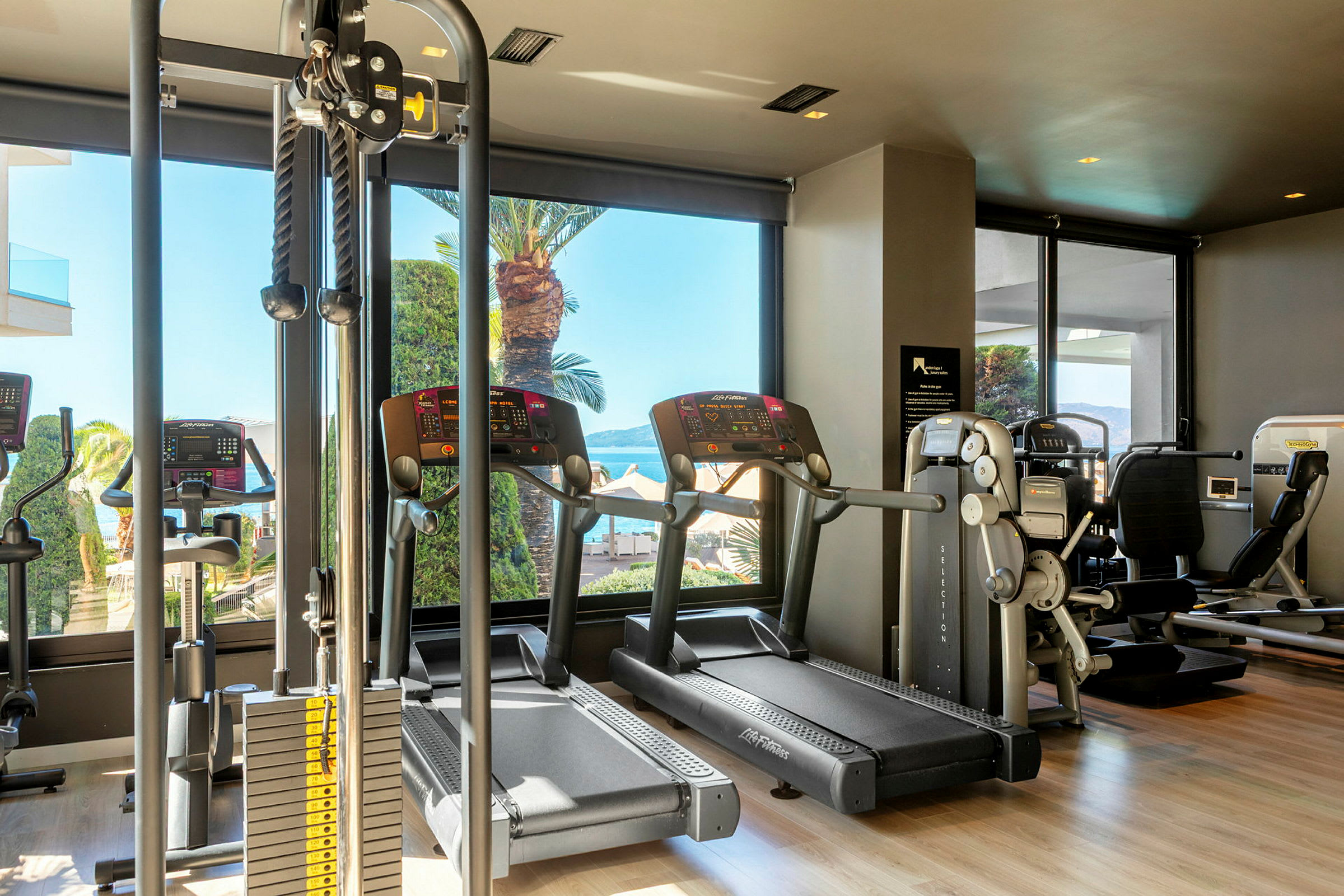 Billede af et fitnesscenter med forskellige træningsmaskiner, herunder løbebånd og styrketræningsudstyr. (AI-genereret tekst)
