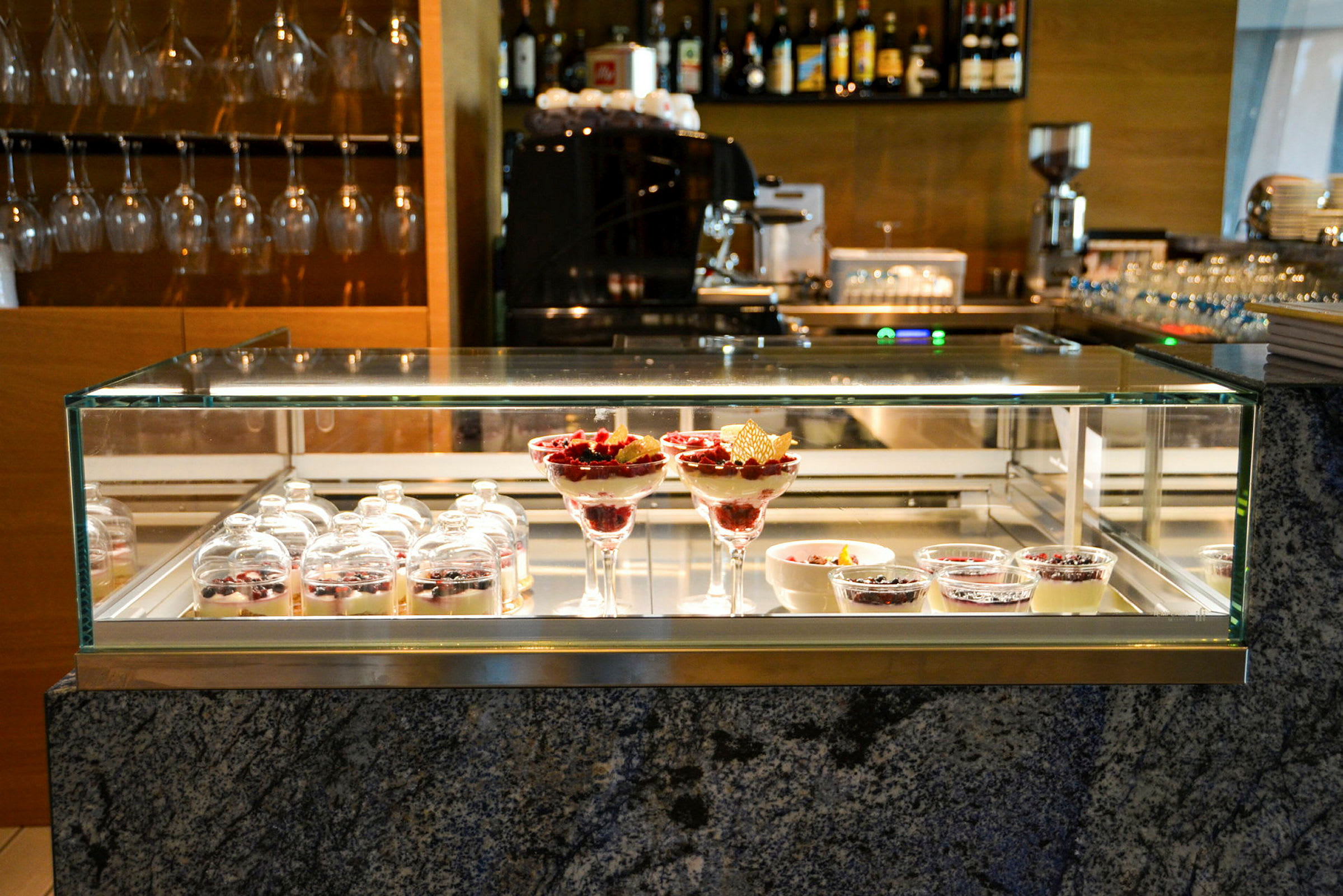 Billede af en glasudstilling med forskellige desserter på en restaurant. (AI-genereret tekst)