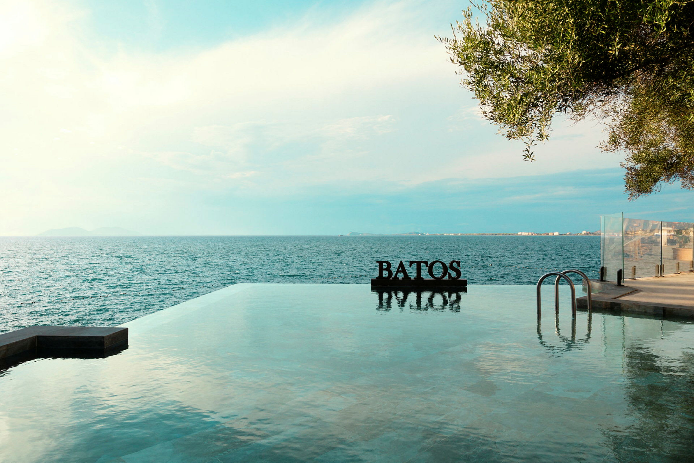 Infinitypool med havudsigt og teksten 'BATOS' synlig ved poolkanten. (AI-genereret tekst)