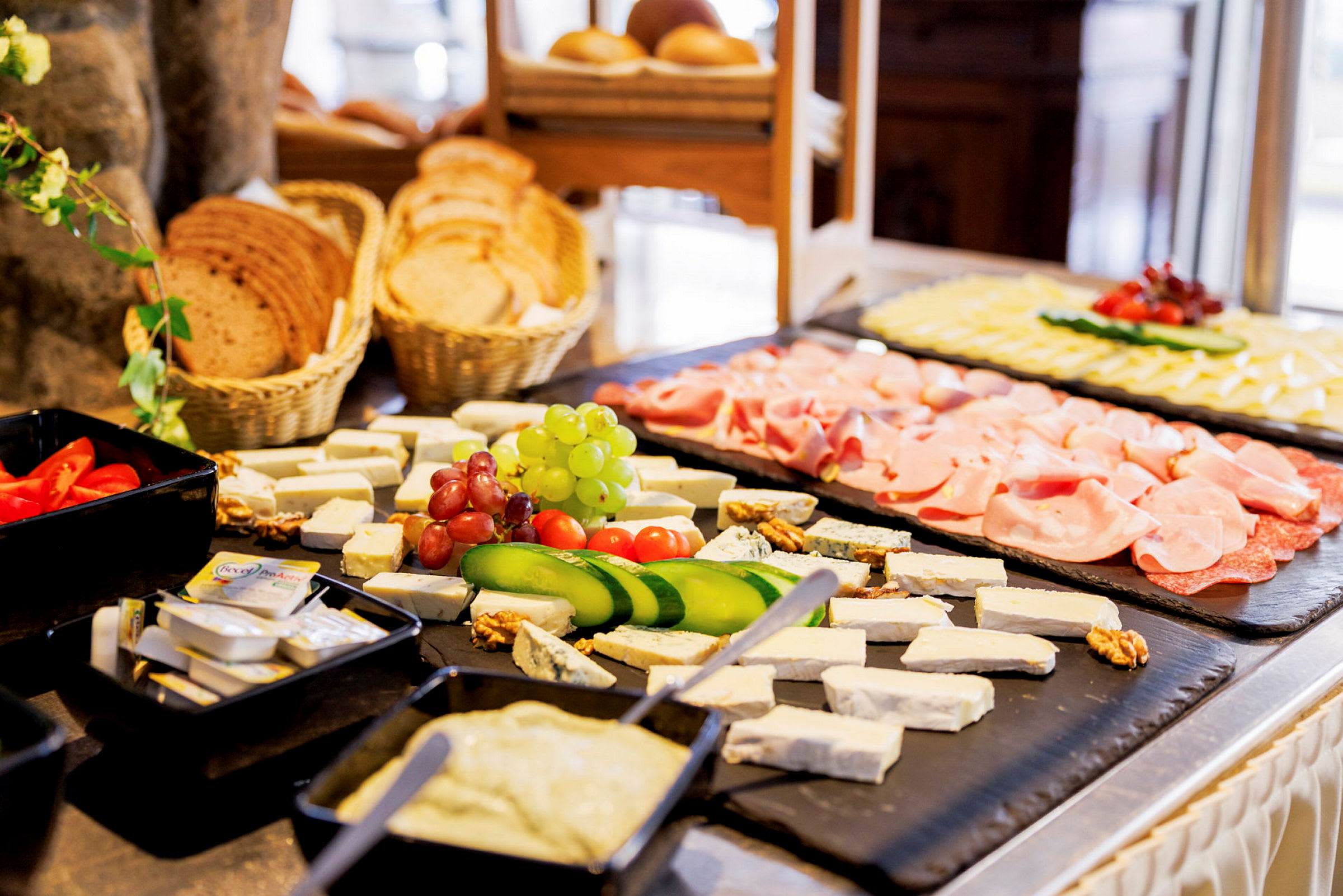 En buffet med forskellige madvarer, herunder ost, grøntsager, kød og brød. (AI-genereret tekst)
