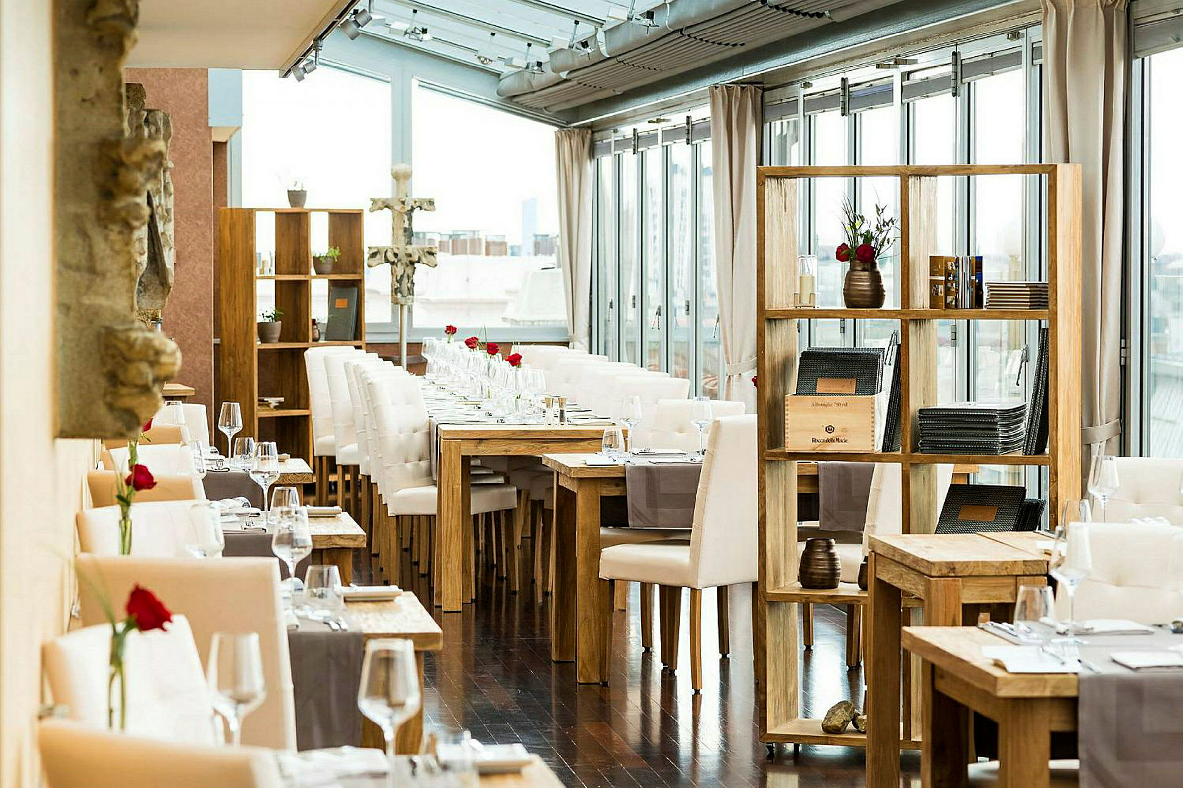 Billede af et lyst restaurantinteriør med dækkede borde og trædetaljer. (AI-genereret tekst)