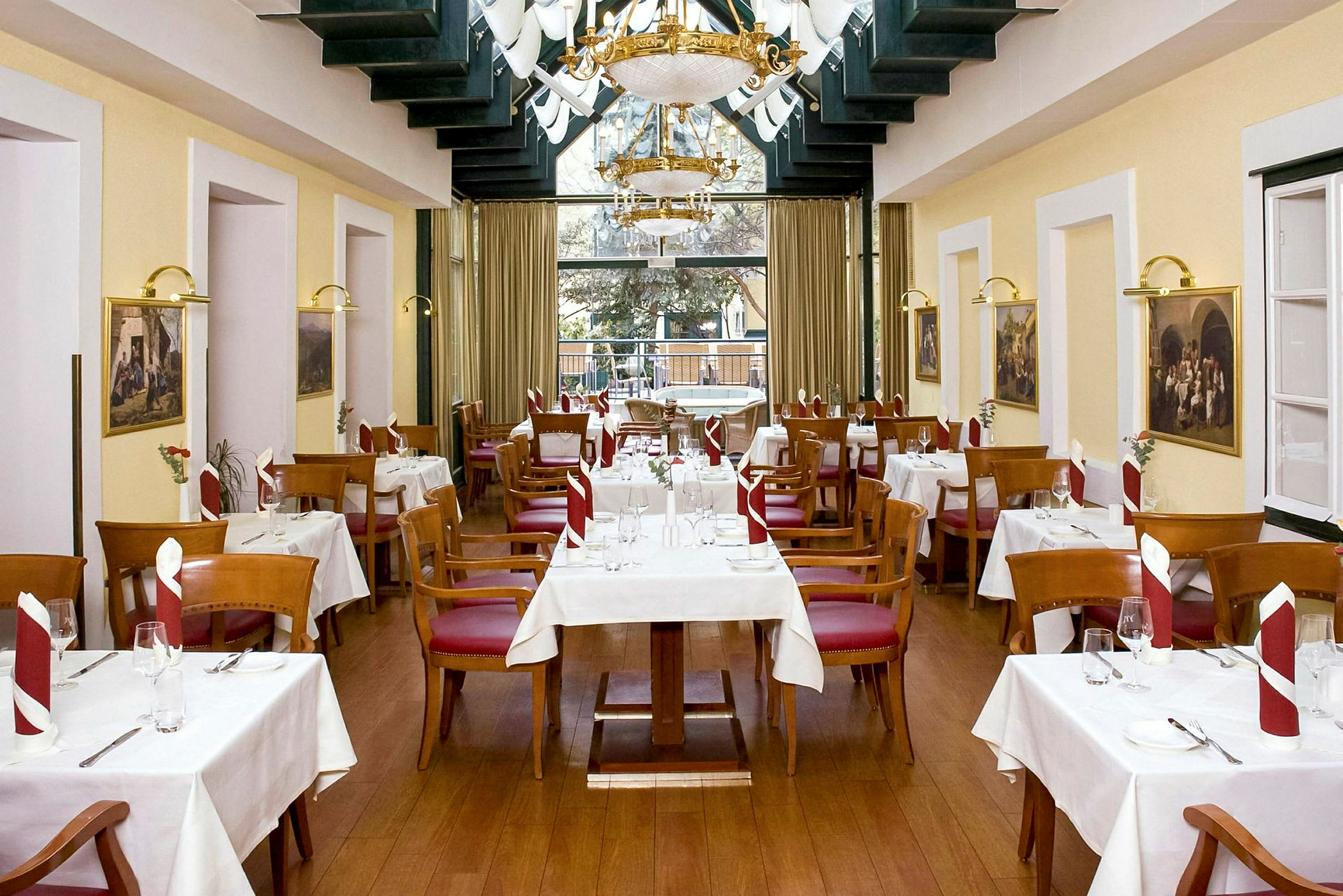 Restaurant med hvide duge på bordene, træstole med røde sæder og pænt foldede servietter. (AI-genereret tekst)