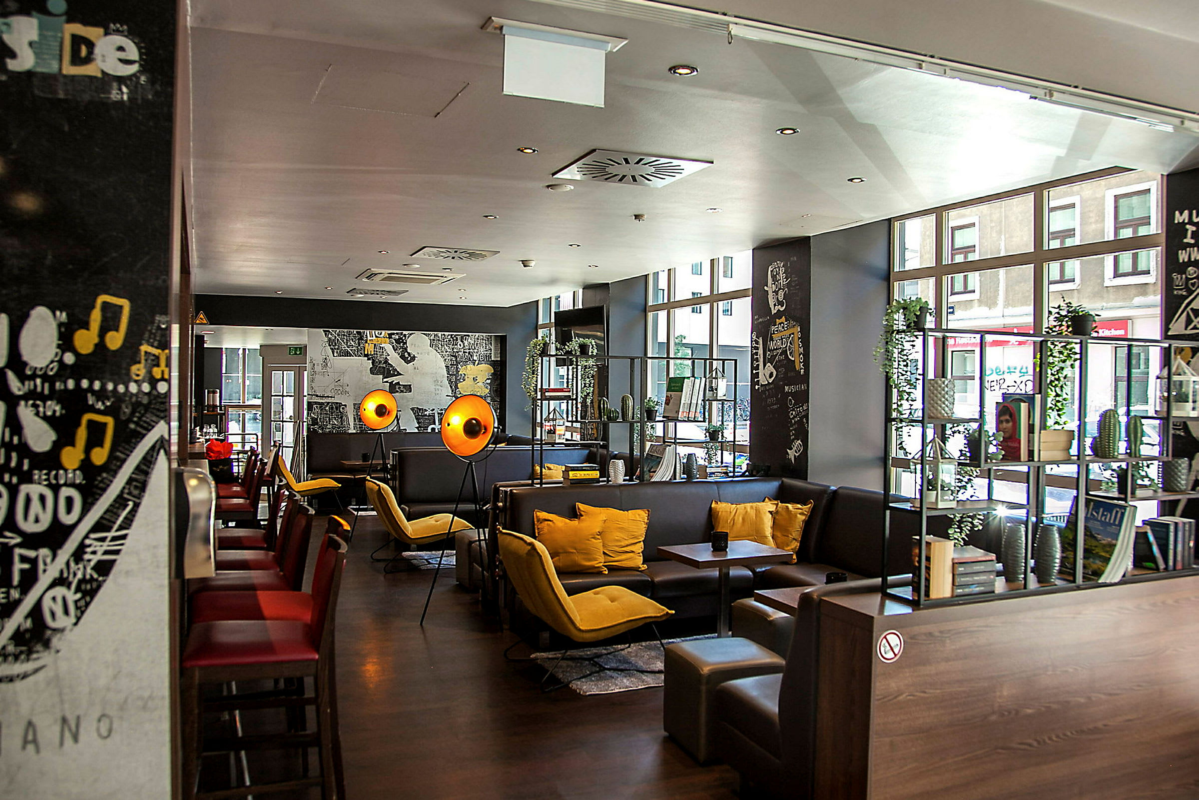 En moderne restaurant eller café med siddemiljøer, farverige puder og dekorationer. (AI-genereret tekst)