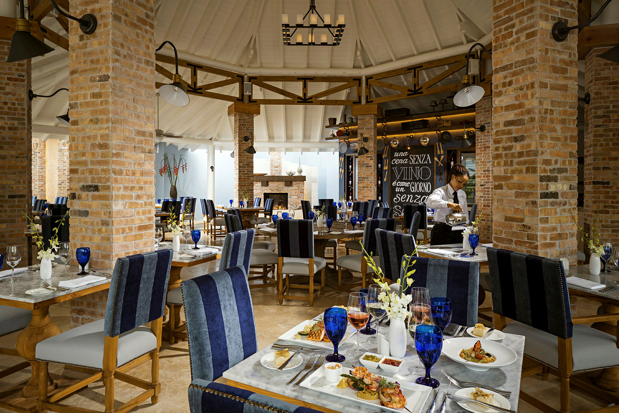 Interiør af en elegant restaurant med oprettede borde og en murstensvæg. (AI-genereret tekst)